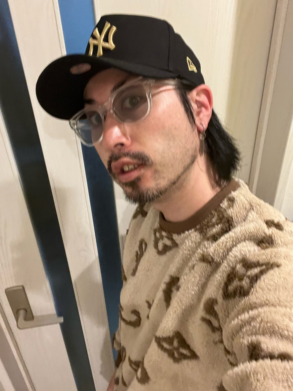 ブラック系のデニムパンツ、ベージュ系のスウェット、ホワイト系のスニーカーを着用したメンズの冬コーディネートの5枚目の写真