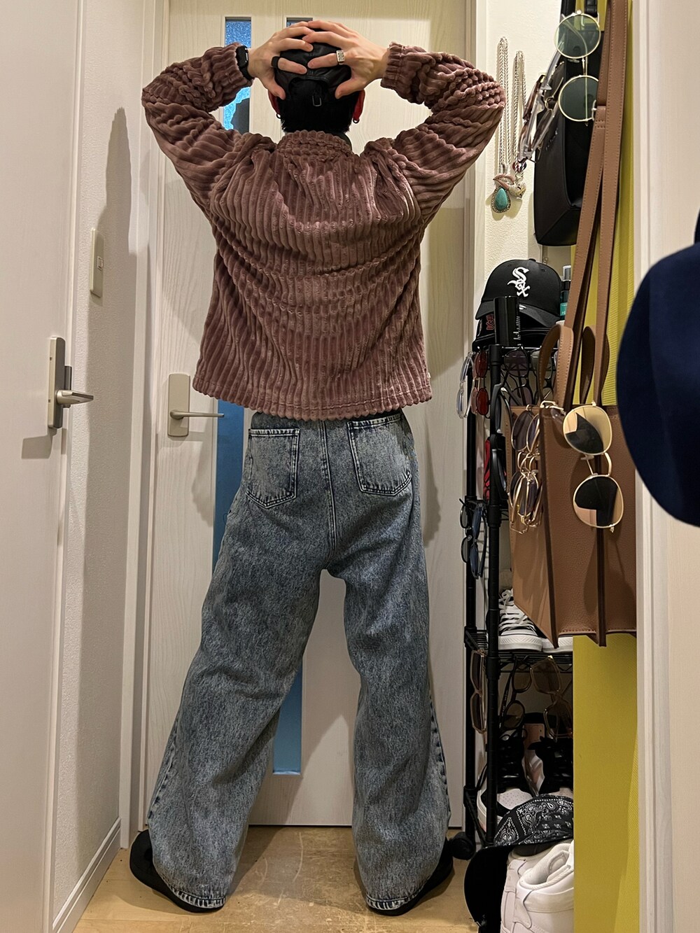 ブルー系のデニムパンツ、ブラック系のスニーカー、ブラウン系のスウェットを着用したメンズの秋コーディネートの4枚目の写真