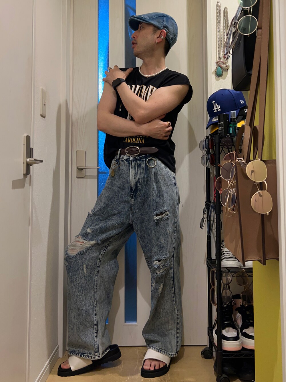 ブルー系のデニムパンツ、ホワイト系のサンダル、ブラック系のタンクトップを着用したメンズの夏コーディネートの3枚目の写真