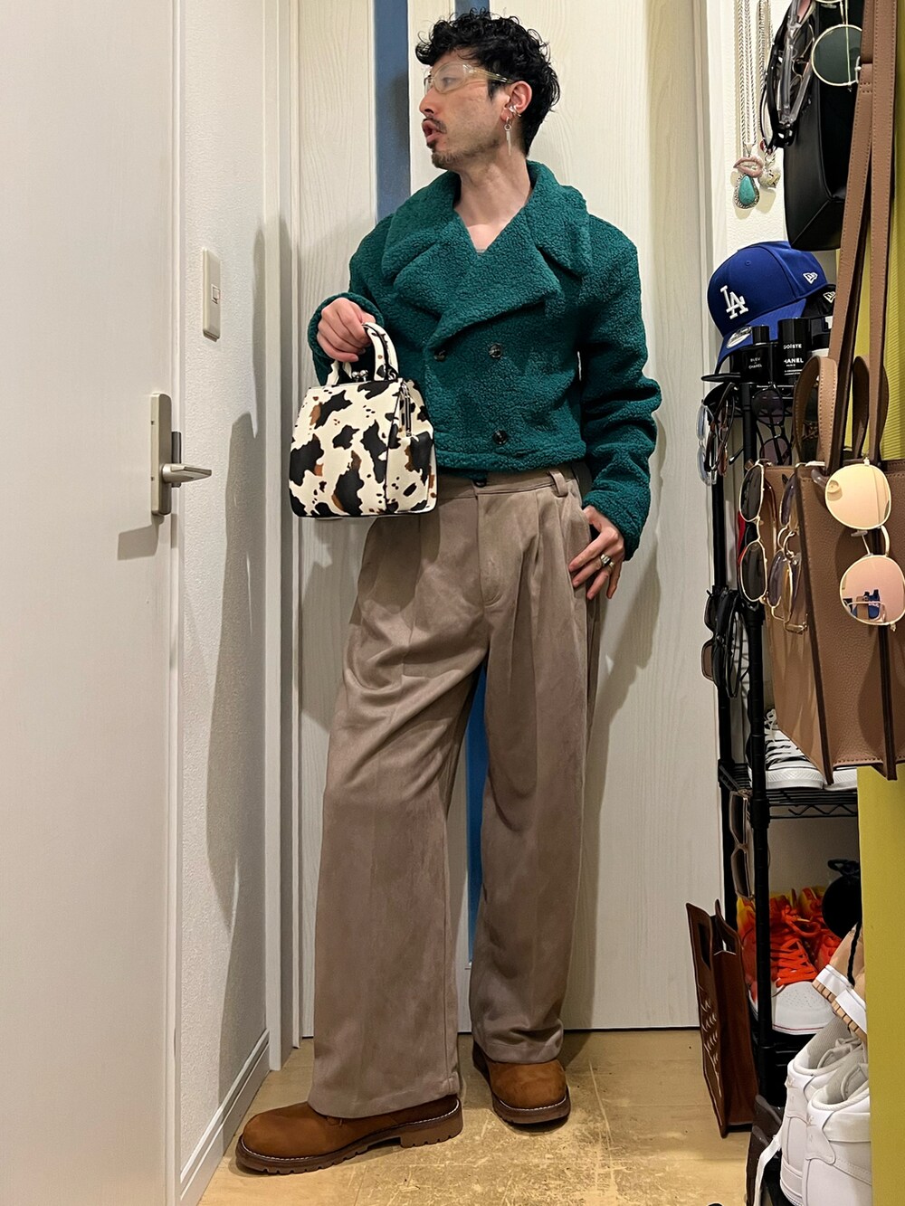 グリーン系のジャケット/アウター、ホワイト系のショルダーバッグ、ベージュ系のスラックスを着用したメンズの冬コーディネートの2枚目の写真