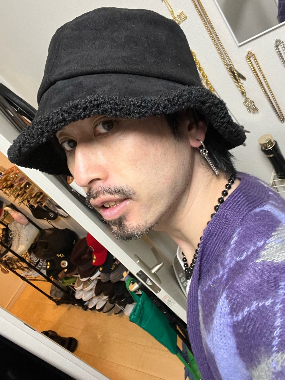 ブルー系のスラックス、ブラック系のブーツ、ベージュ系のタンクトップを着用したメンズの秋コーディネートの3枚目の写真