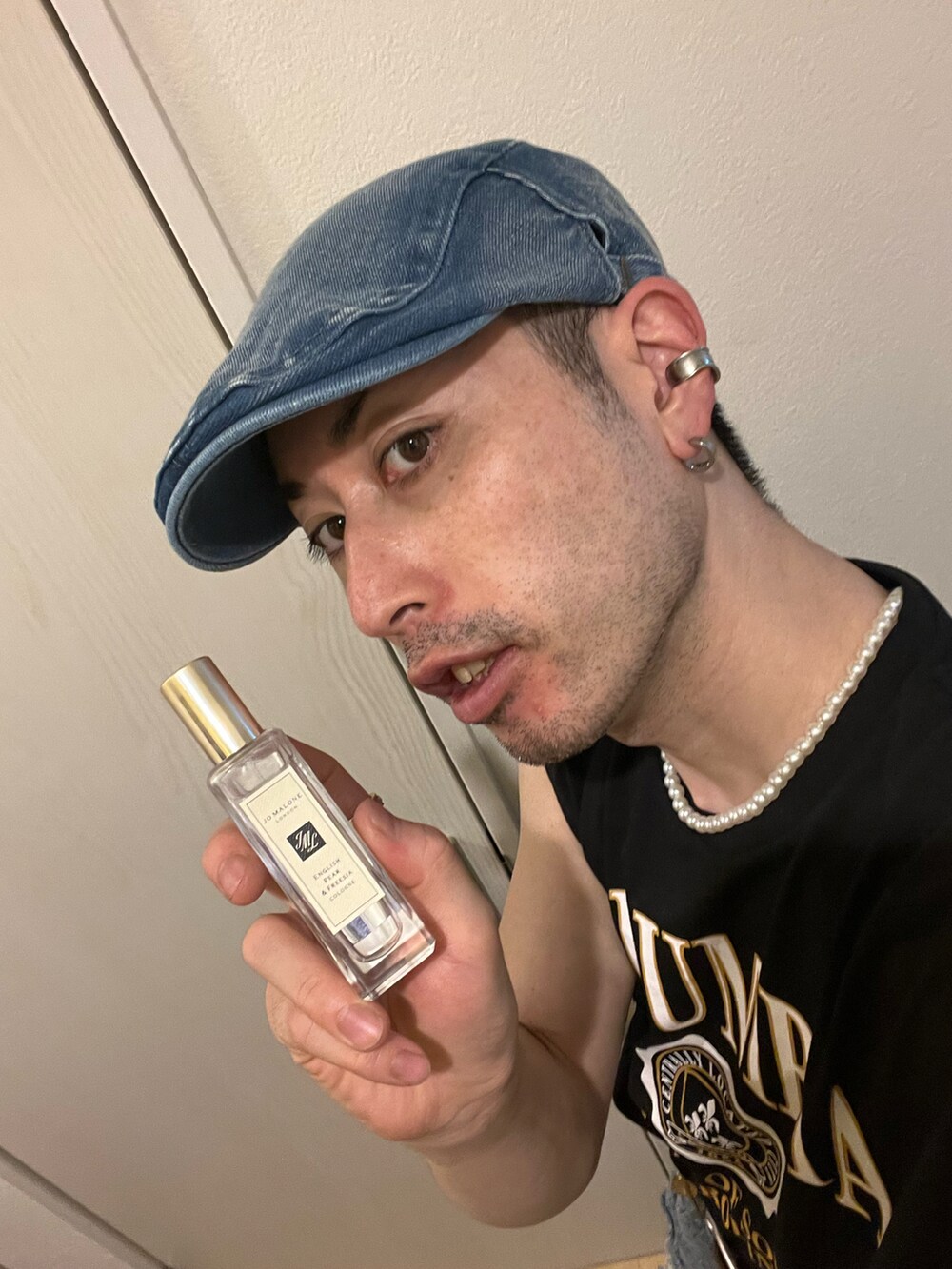 ブルー系のデニムパンツ、ホワイト系のサンダル、ブラック系のタンクトップを着用したメンズの夏コーディネートの5枚目の写真