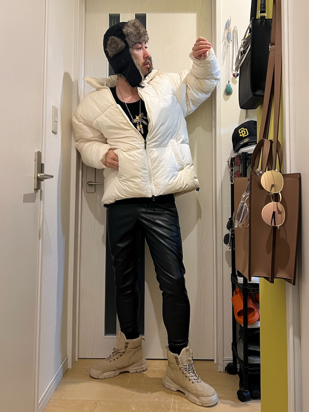 ホワイト系のダウンジャケット/コート、ブラック系のその他パンツ、ブラック系のキャップを着用したメンズの冬コーディネートの3枚目の写真