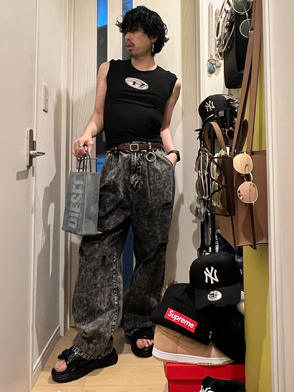 ブルー系のショルダーバッグ、ブラック系のデニムパンツ、ブラック系のサンダルを着用したメンズの春コーディネートの2枚目の写真