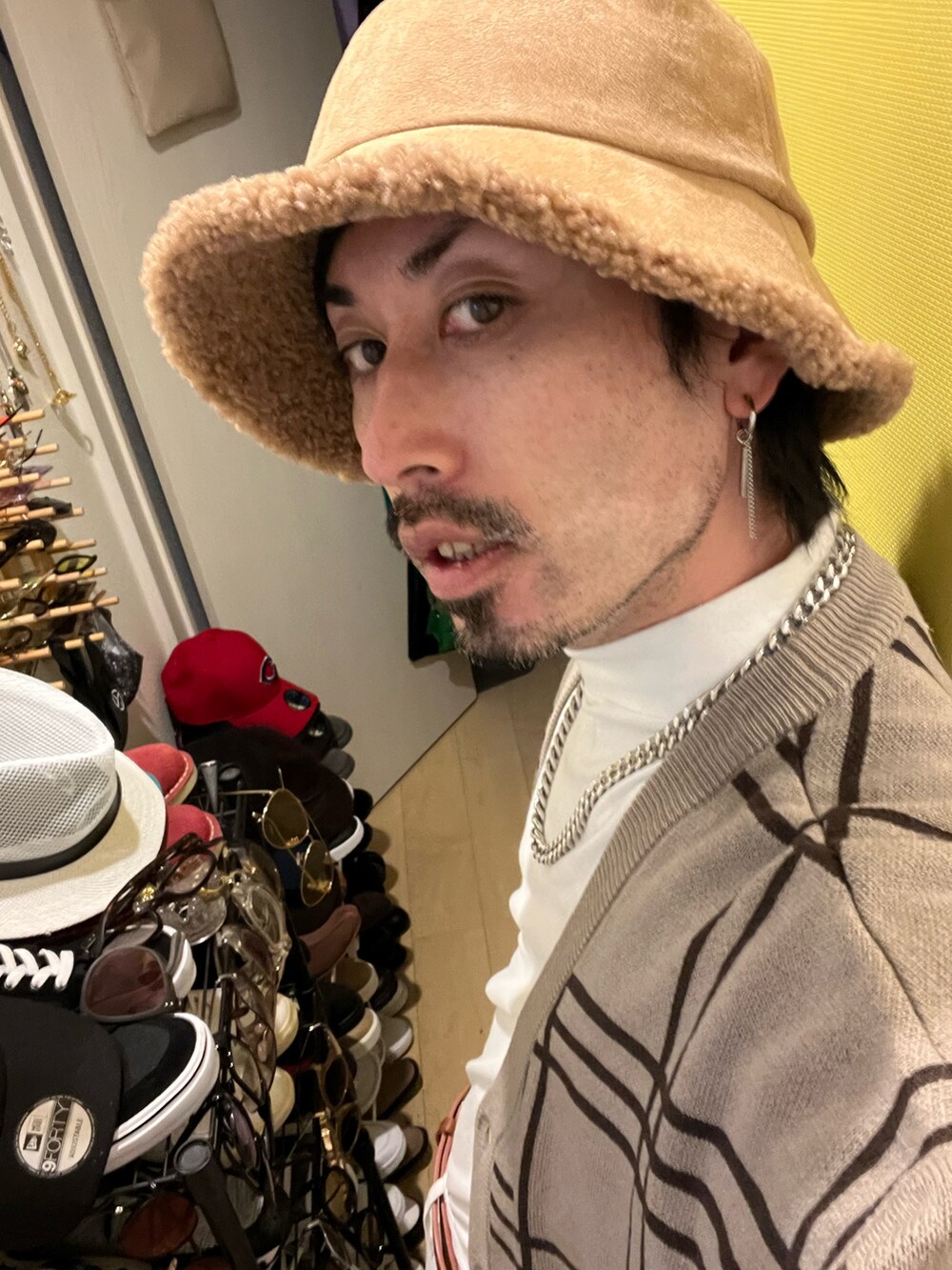 ホワイト系のショルダーバッグ、ベージュ系のカーディガン/ボレロ、ホワイト系のスラックスを着用したメンズの秋コーディネートの5枚目の写真