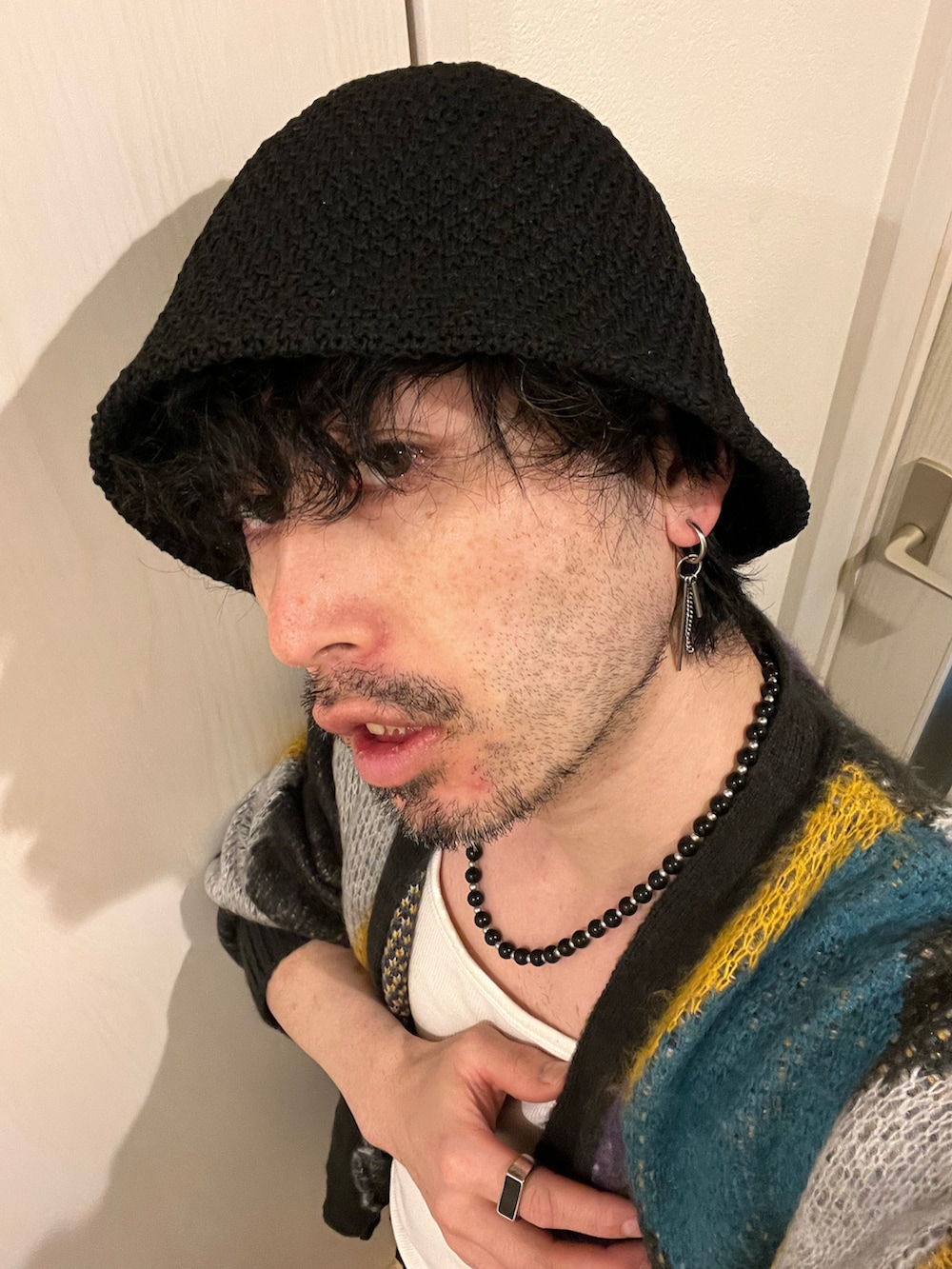 ブラック系のカーゴパンツ、ブラック系のブーツ、グリーン系のショルダーバッグを着用したメンズの春コーディネートの4枚目の写真