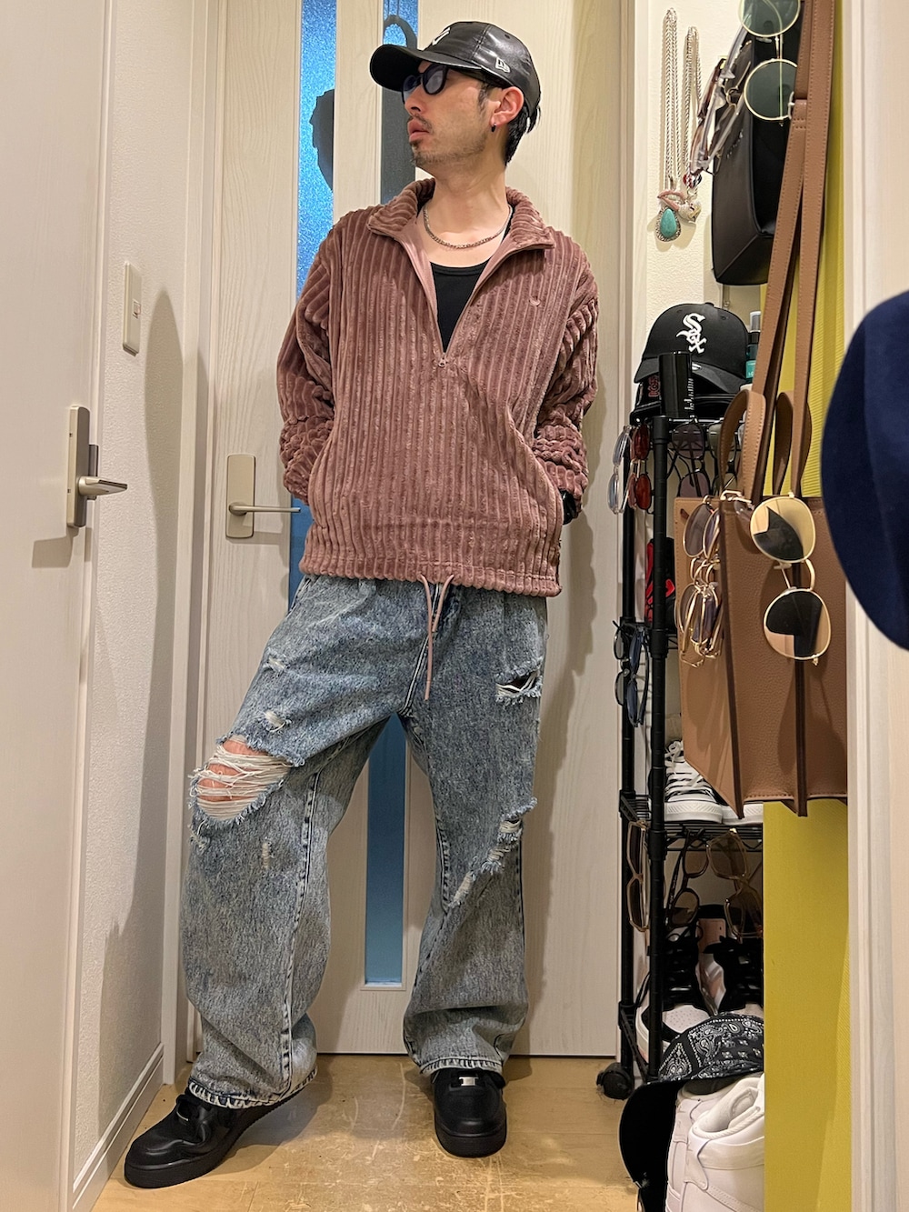 ブルー系のデニムパンツ、ブラック系のスニーカー、ブラウン系のスウェットを着用したメンズの秋コーディネートの2枚目の写真