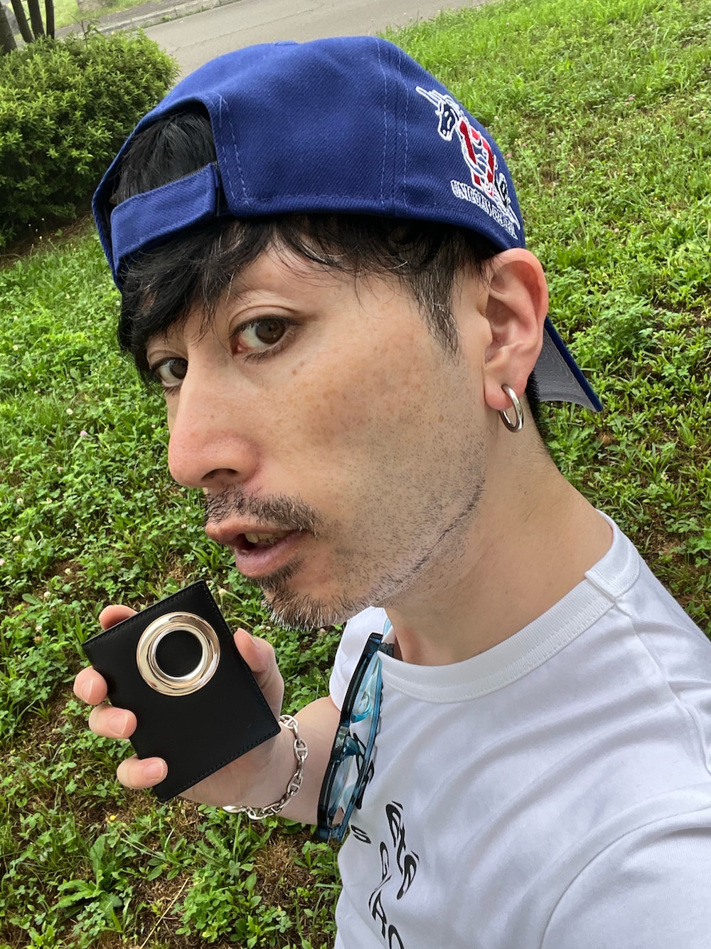 ホワイト系のTシャツ/カットソー、ブルー系のデニムパンツ、ブラック系のスニーカーを着用したメンズの夏コーディネートの3枚目の写真