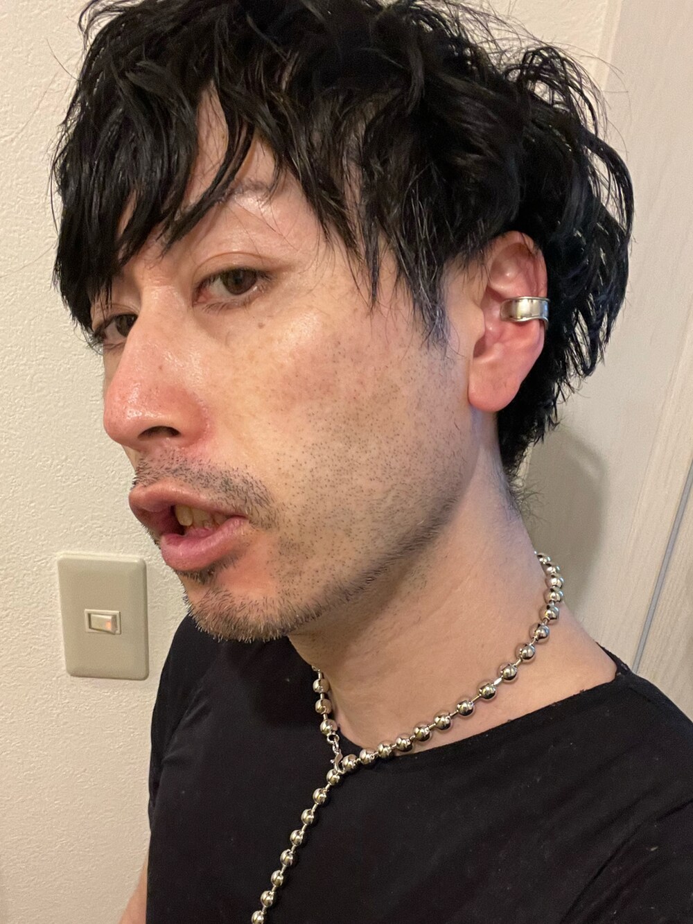 ブラック系のボディバッグ/ウエストポーチ、グレー系のデニムパンツ、ブラック系のスニーカーを着用したメンズの春コーディネートの4枚目の写真