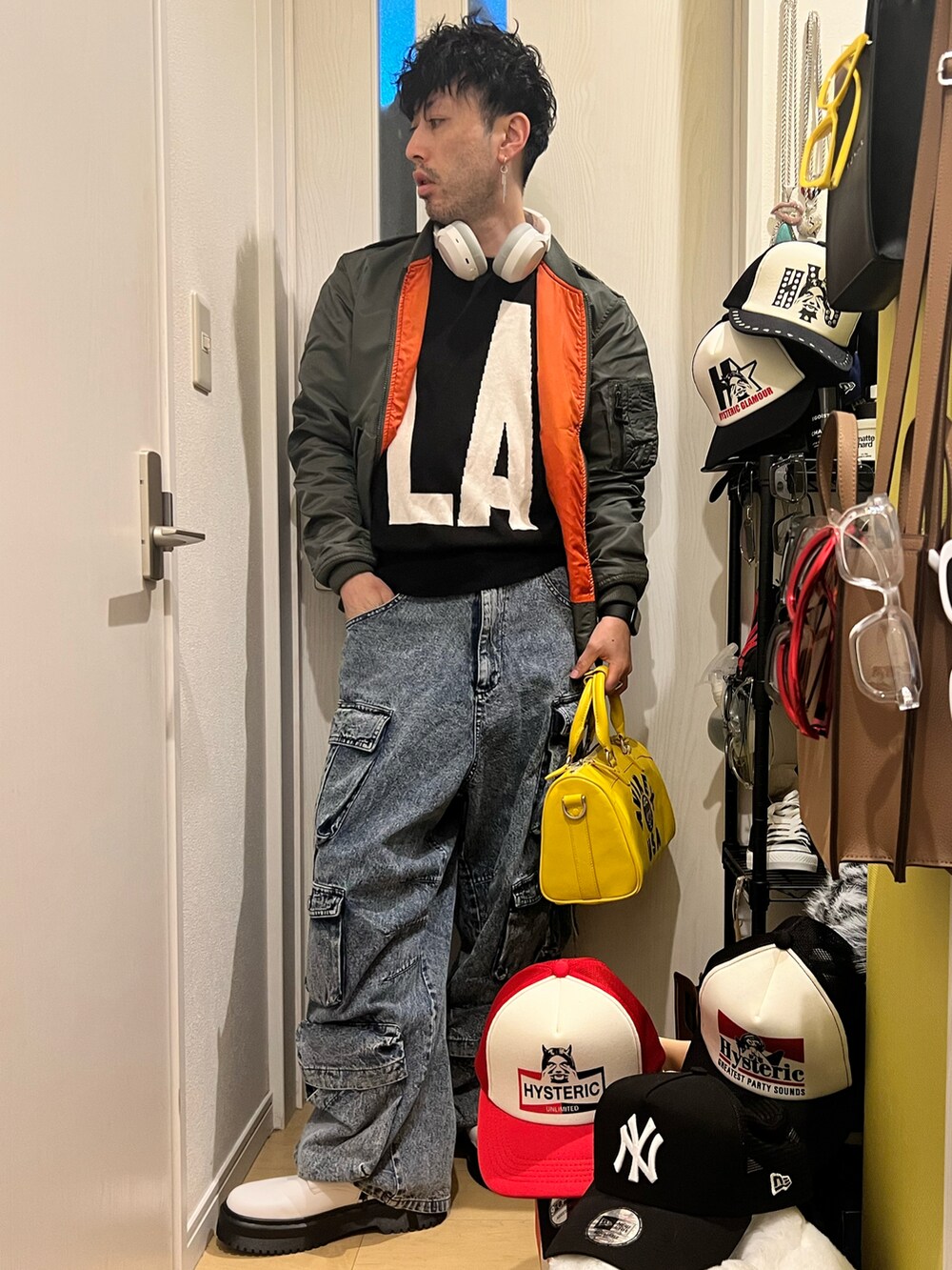 イエロー系のボストンバッグ、ブルー系のカーゴパンツ、ホワイト系のブーツを着用したメンズの冬コーディネートの3枚目の写真