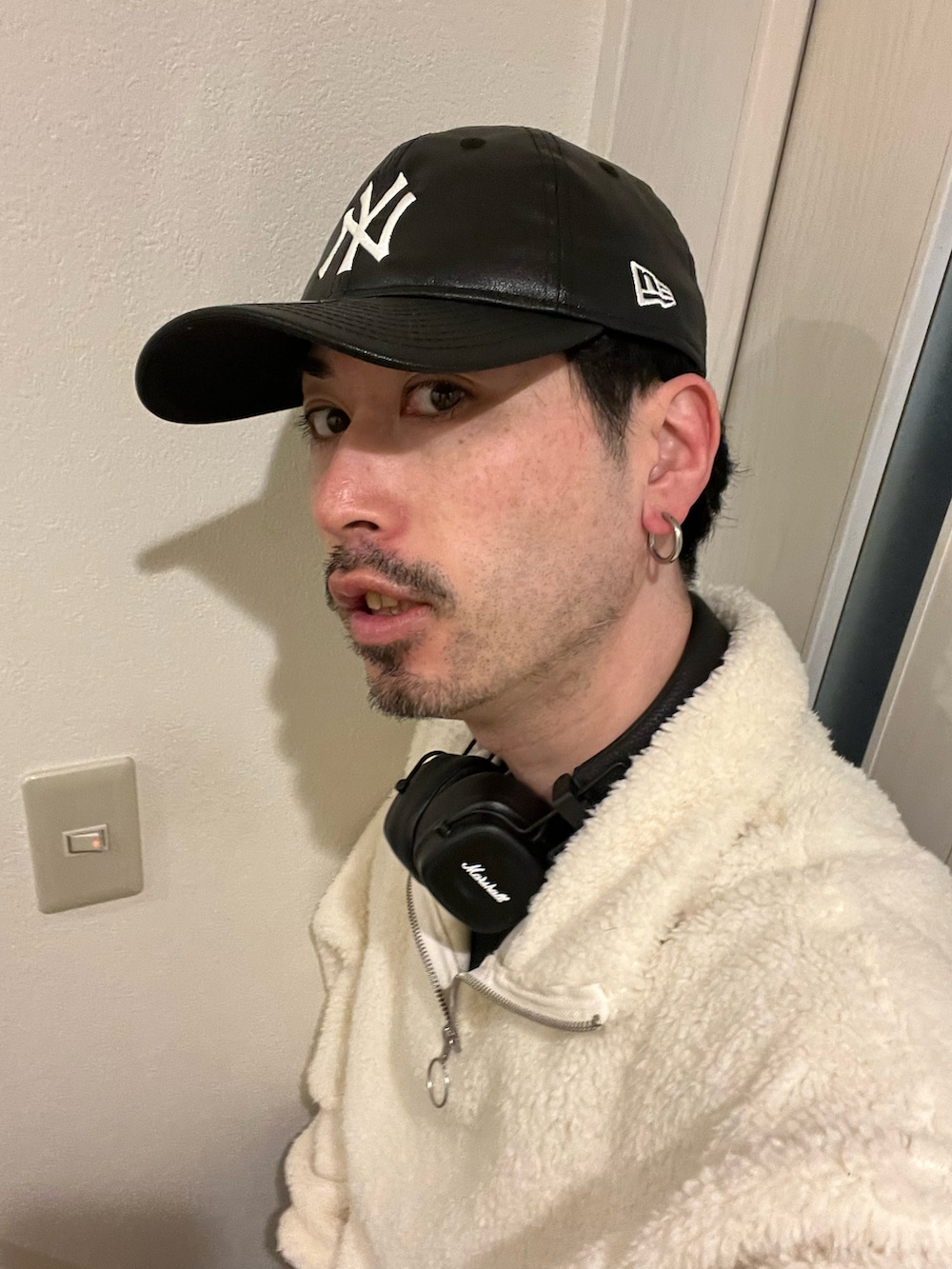 ブラック系のスニーカー、ホワイト系のスウェット、その他のキャップを着用したメンズの冬コーディネートの4枚目の写真