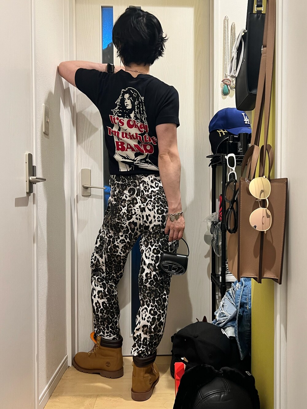 ブラック系のTシャツ/カットソー、ベージュ系のブーツ、ブラック系のショルダーバッグを着用したメンズの夏コーディネートの3枚目の写真