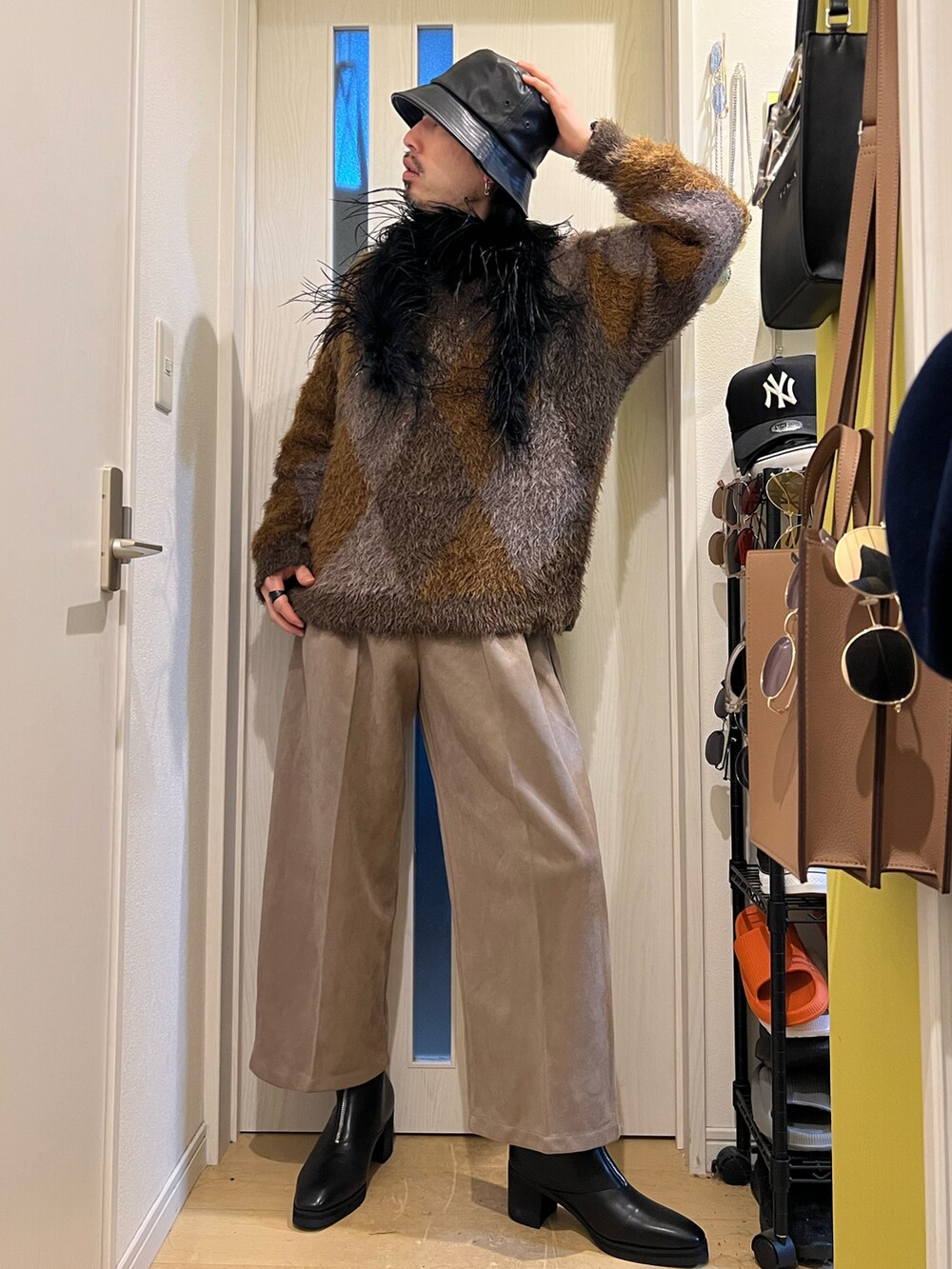 ブラウン系のニット/セーター、ベージュ系のスラックス、ブラック系のブーツを着用したメンズの冬コーディネートの5枚目の写真