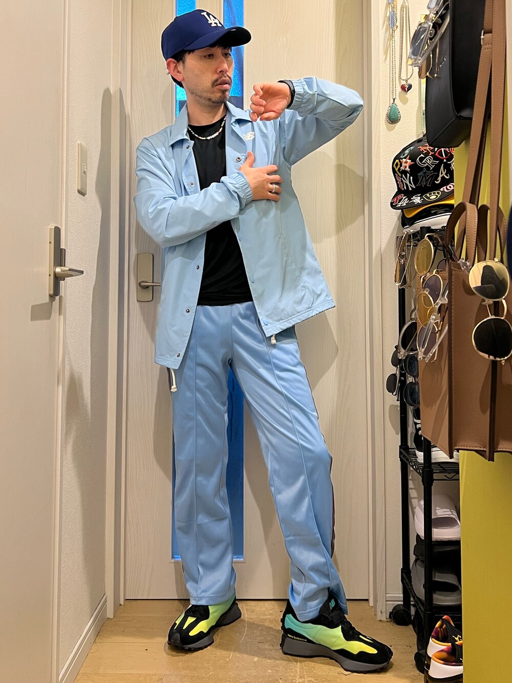 ブルー系のデニムパンツ、ブラック系のスニーカー、ブルー系のキャップを着用したメンズの春コーディネートの2枚目の写真
