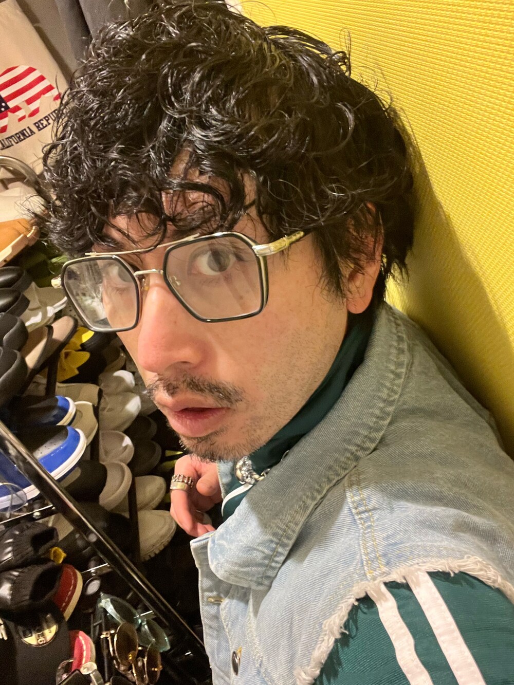 ブラック系のカーゴパンツ、ブラック系のスニーカー、ホワイト系のショルダーバッグを着用したメンズの春コーディネートの5枚目の写真