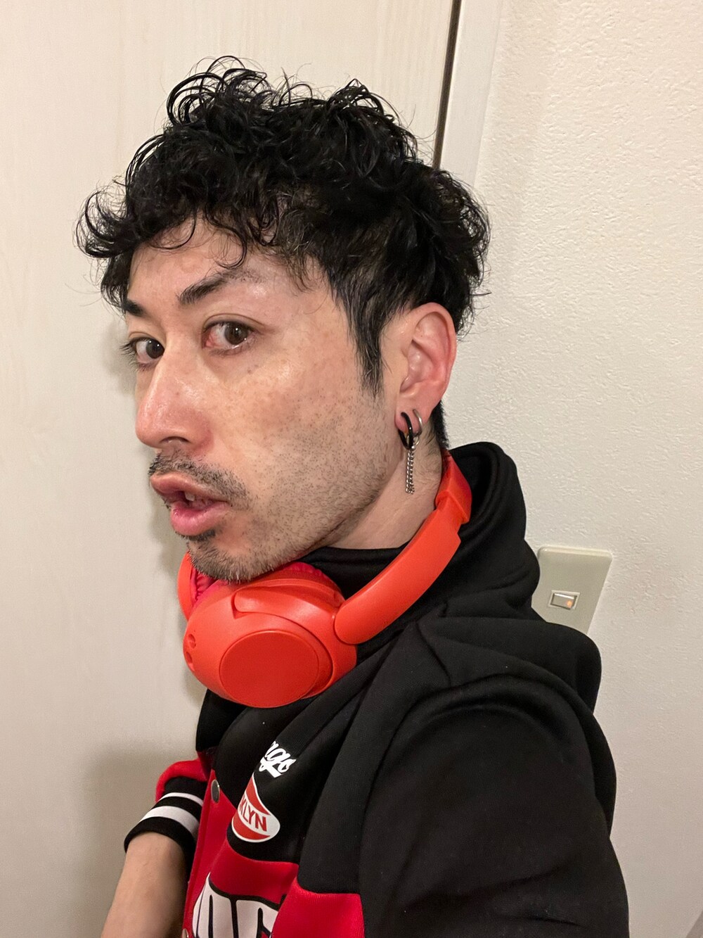 ブルー系のデニムパンツ、ブラック系のスニーカー、レッド系のジャケット/アウターを着用したメンズの冬コーディネートの5枚目の写真