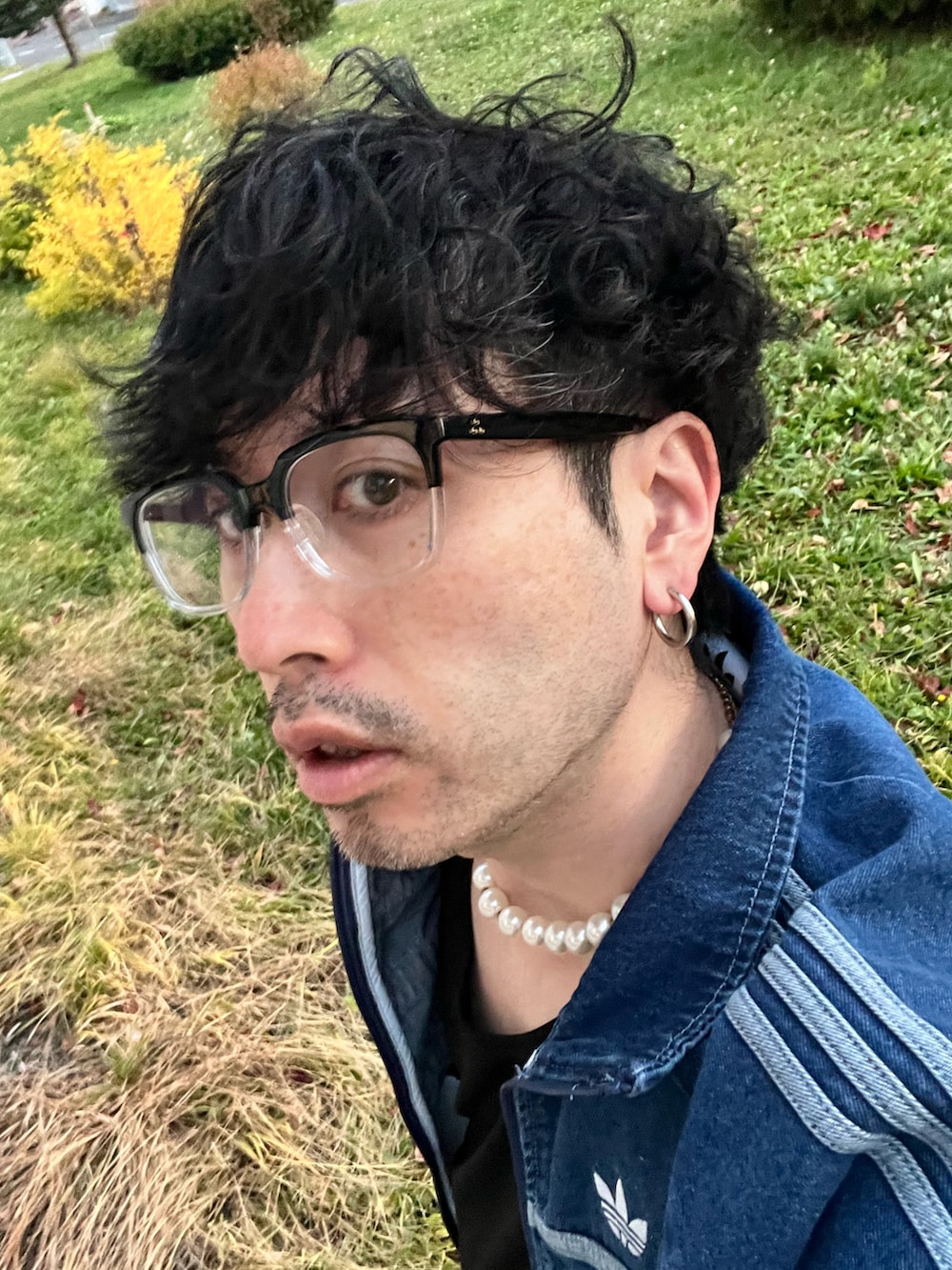 ブラック系のスニーカー、ブラック系のハンドバッグ、ブラック系のタンクトップを着用したメンズの秋コーディネートの5枚目の写真