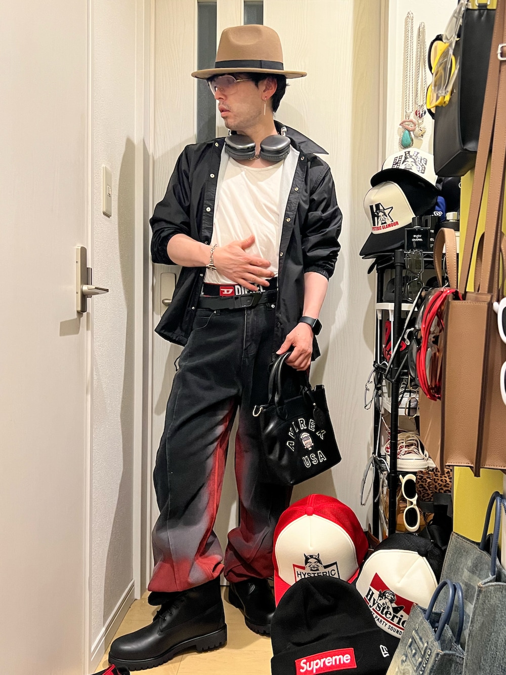 ブラック系のデニムパンツ、ブラック系のブルゾン、ブラック系のトートバッグを着用したメンズの春コーディネートの2枚目の写真