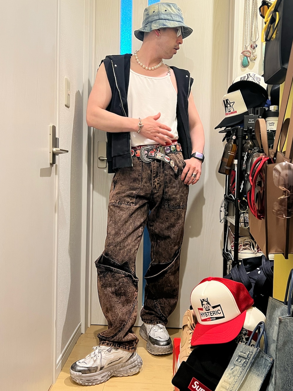 ブラウン系のデニムパンツ、ホワイト系のスニーカー、ホワイト系のボクサーパンツを着用したメンズの春コーディネートの2枚目の写真