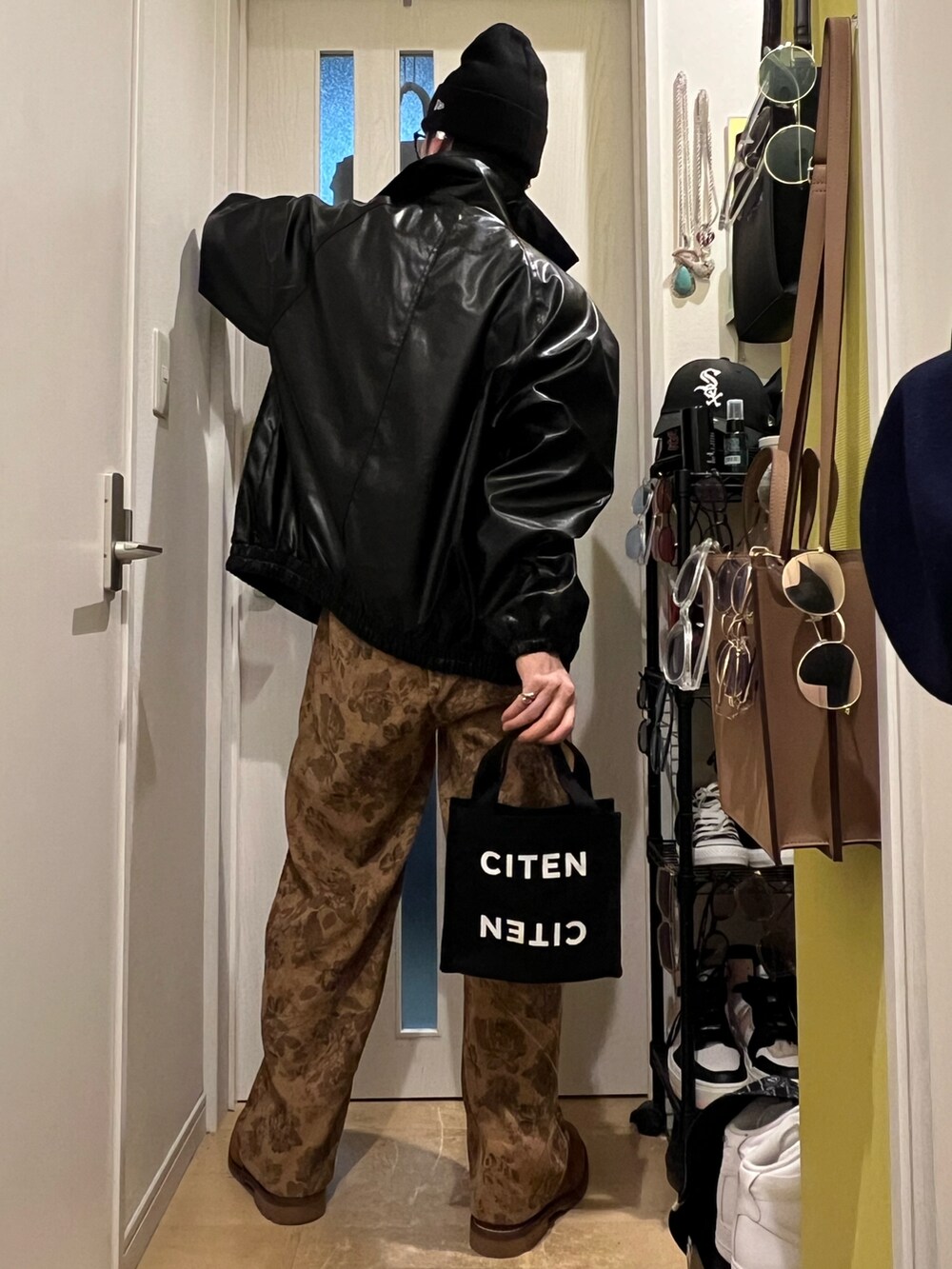 ブラック系のトートバッグ、ブラウン系のその他パンツ、ブラウン系のブーツを着用したメンズの秋コーディネートの4枚目の写真