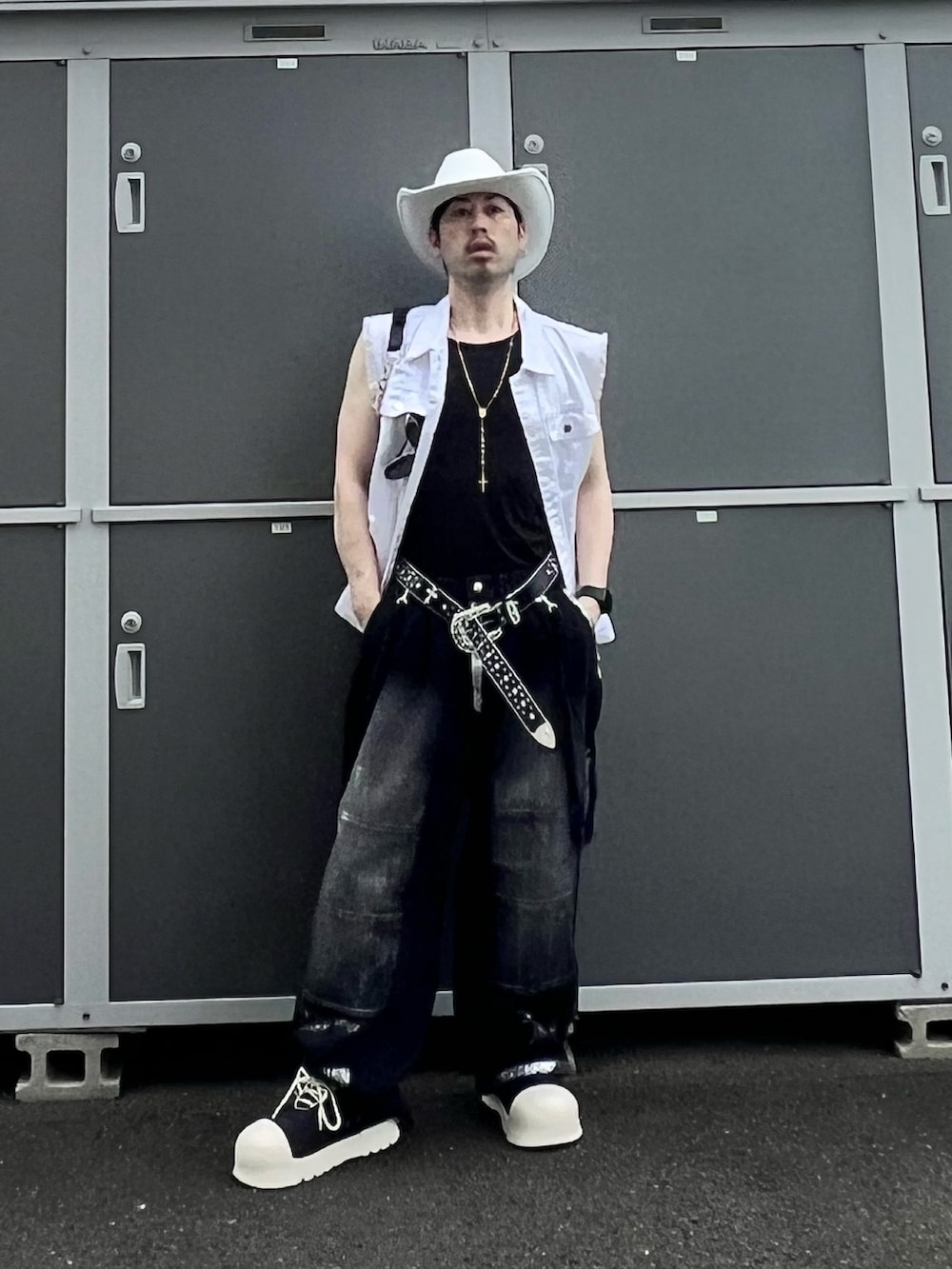 ブラック系のデニムパンツ、ブラック系のスニーカー、ブラック系のショルダーバッグを着用したメンズの夏コーディネートの3枚目の写真