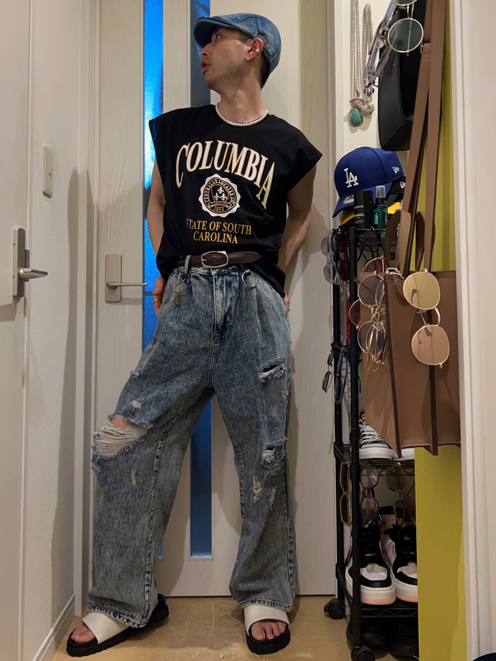 ブルー系のデニムパンツ、ホワイト系のサンダル、ブラック系のタンクトップを着用したメンズの夏コーディネートの2枚目の写真