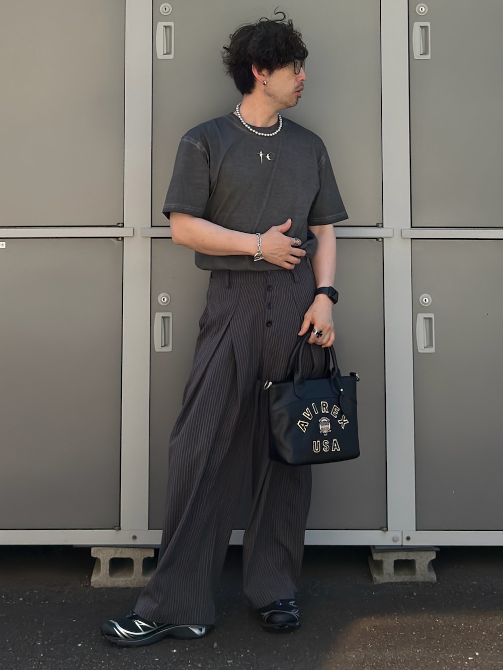 ブラック系のトートバッグ、グレー系のTシャツ/カットソー、ブラック系のスニーカーを着用したメンズの夏コーディネートの2枚目の写真