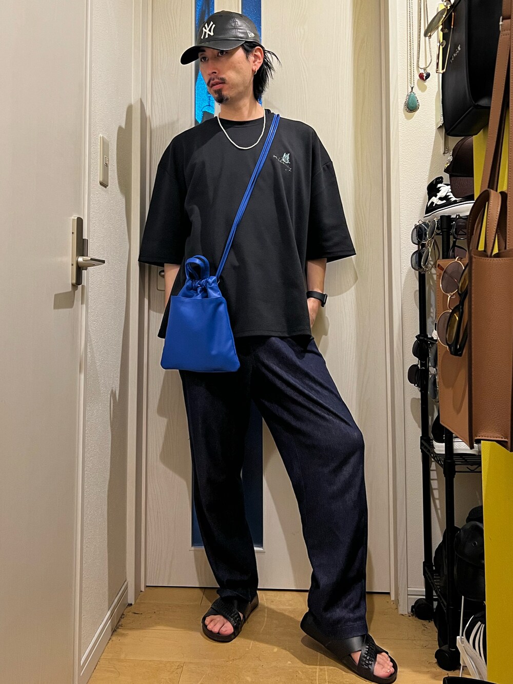 グリーン系のショルダーバッグ、ブラック系のTシャツ/カットソー、ブラック系のサンダルを着用したメンズの夏コーディネートの4枚目の写真