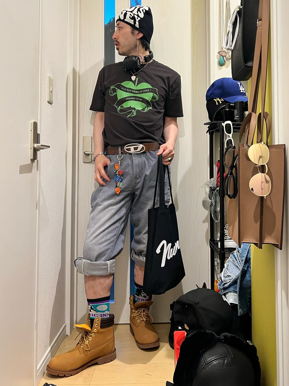 グレー系のTシャツ/カットソー、ブラック系のトートバッグ、ベージュ系のブーツを着用したメンズの夏コーディネートの3枚目の写真