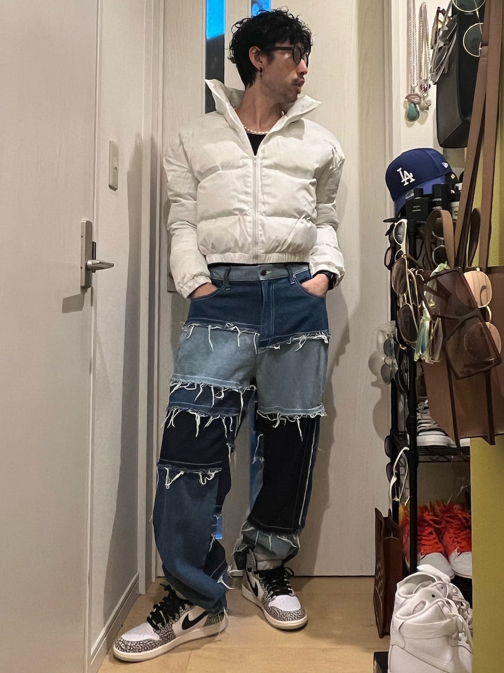 ブルー系のデニムパンツ、グレー系のスニーカー、ホワイト系のダウンジャケット/コートを着用したメンズの冬コーディネートの2枚目の写真