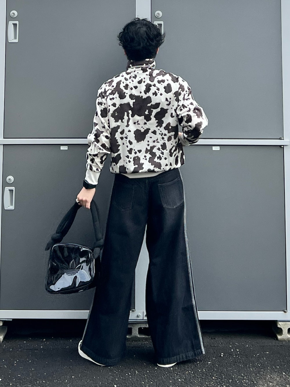 ブラック系のデニムパンツ、ブラック系のスニーカー、ホワイト系のジャージを着用したメンズの秋コーディネートの3枚目の写真