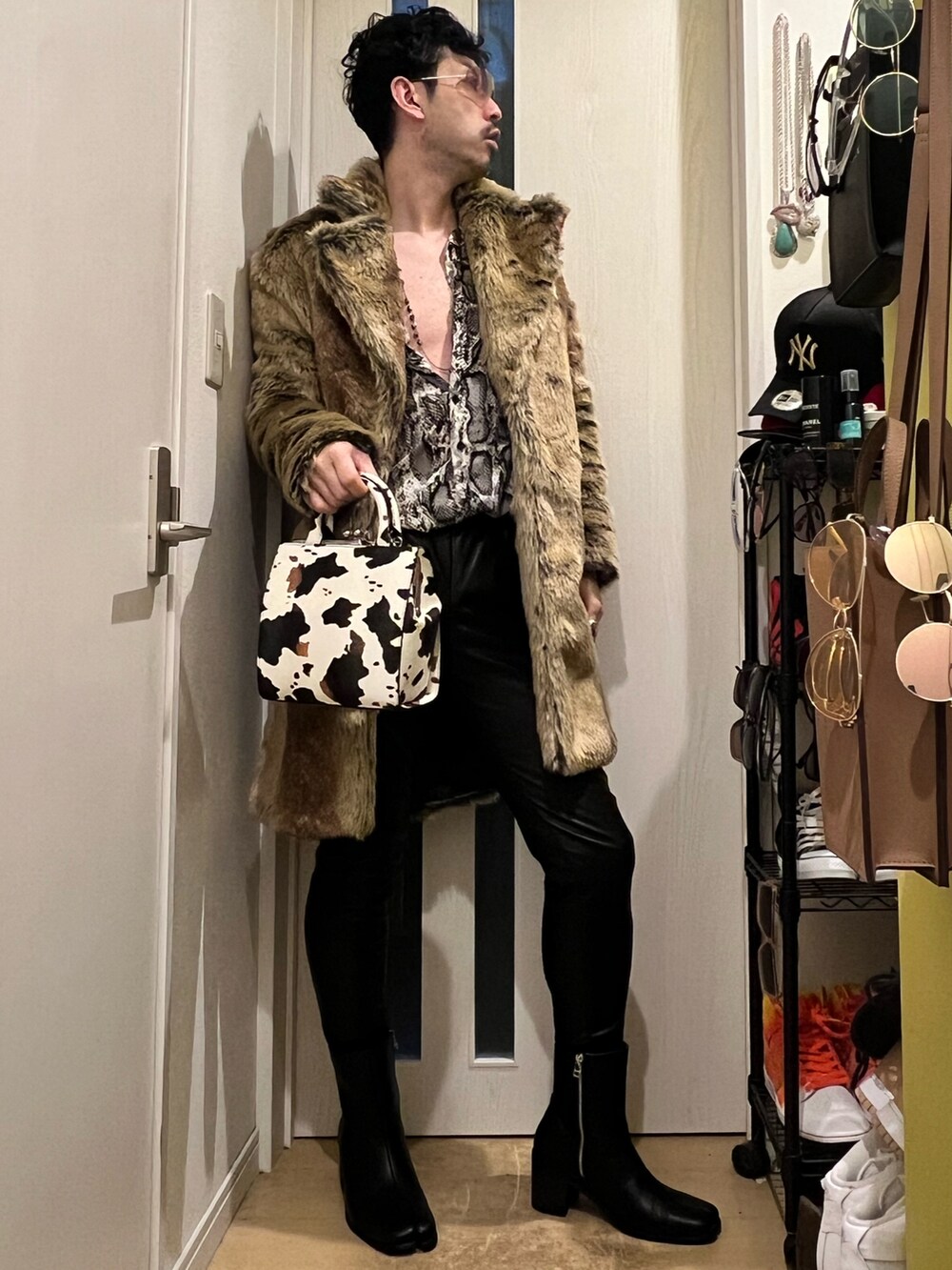 ブラック系のスウェットパンツ、ブラック系のブーツ、ホワイト系のショルダーバッグを着用したメンズの冬コーディネートの3枚目の写真