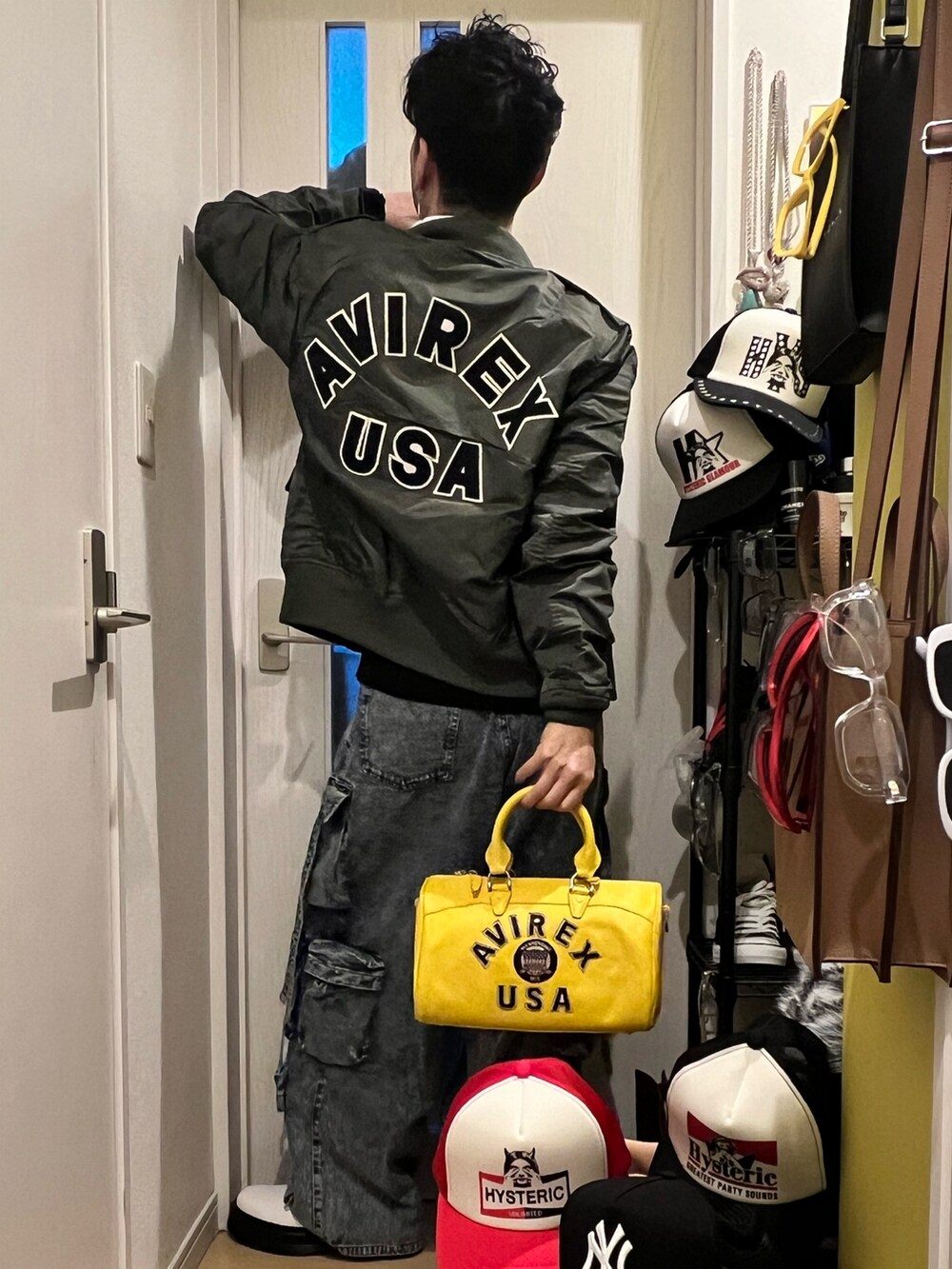 イエロー系のボストンバッグ、ブルー系のカーゴパンツ、ホワイト系のブーツを着用したメンズの冬コーディネートの2枚目の写真