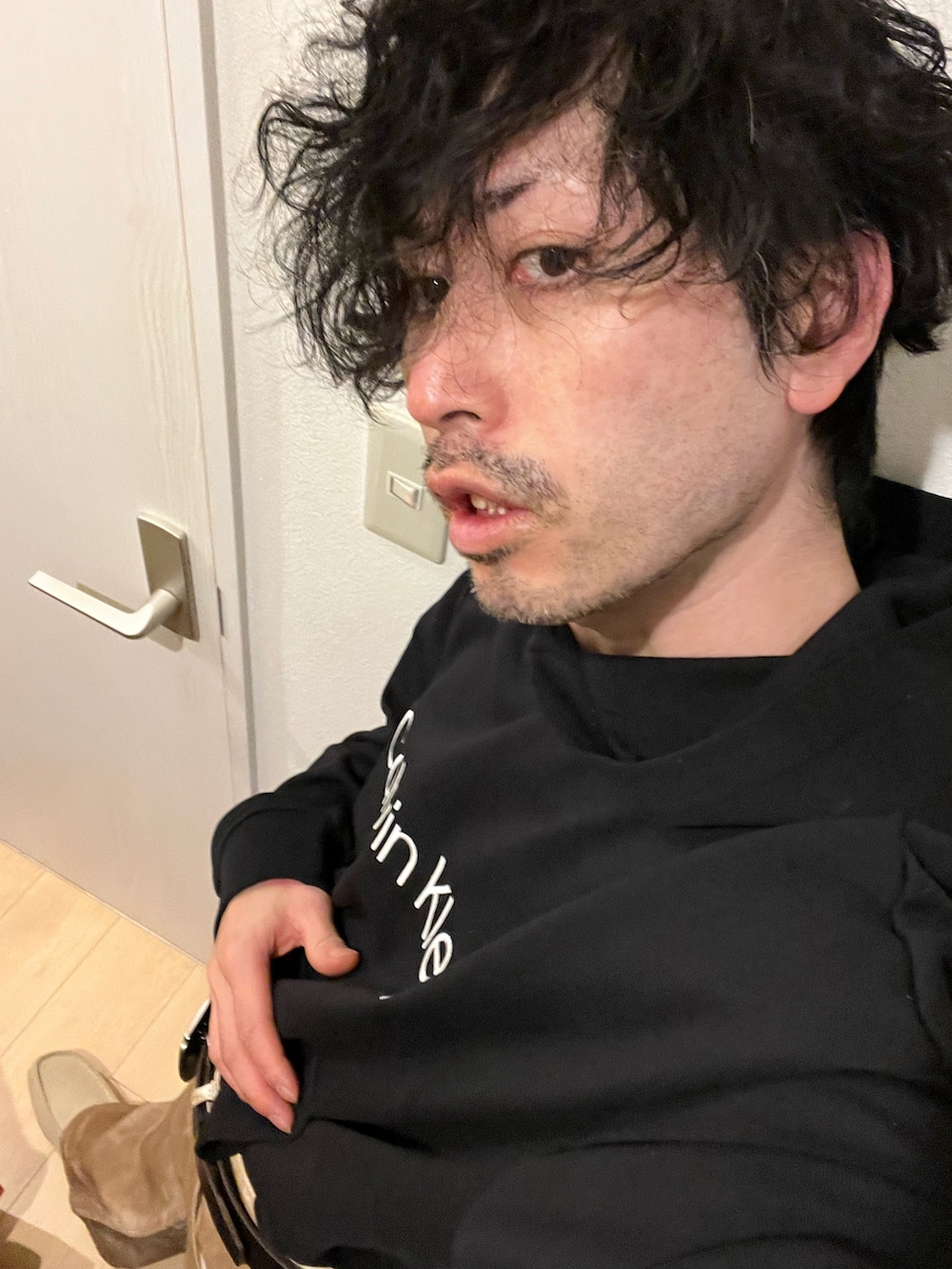 ブラック系のパーカー、ブラウン系のデニムパンツ、ベージュ系のブーツを着用したメンズの冬コーディネートの5枚目の写真