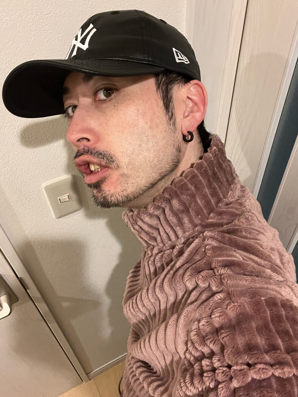 ブルー系のデニムパンツ、ブラック系のスニーカー、ブラウン系のスウェットを着用したメンズの秋コーディネートの5枚目の写真