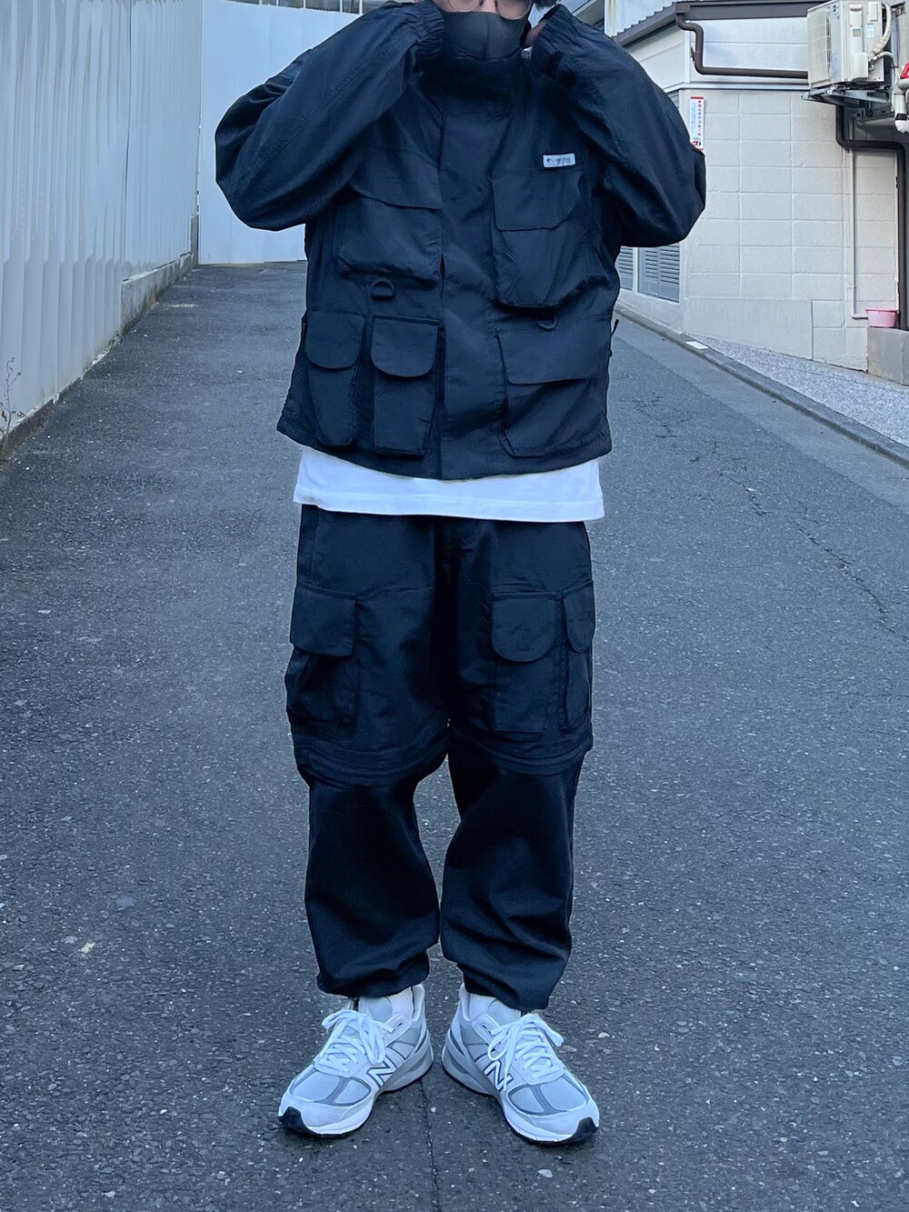 ブラック系のブルゾン、ブラック系のカーゴパンツ、グレー系のスニーカーを着用したメンズの冬コーディネートの2枚目の写真