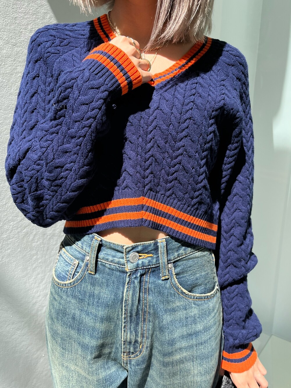 ブルー系のニット/セーター、ブルー系のデニムパンツを着用したレディースの秋コーディネートの5枚目の写真