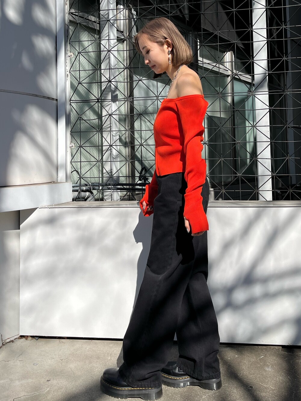 ブラック系のニット/セーター、ブラック系のデニムパンツを着用したレディースの春コーディネートの2枚目の写真