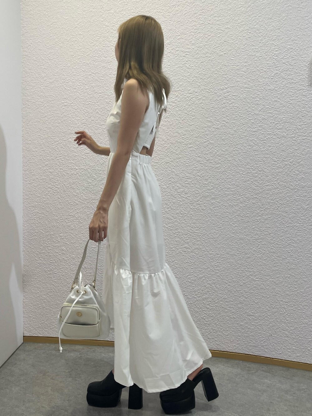 ホワイト系のサンダル、ホワイト系のショルダーバッグ、ホワイト系のワンピースを着用したレディースの夏コーディネートの4枚目の写真