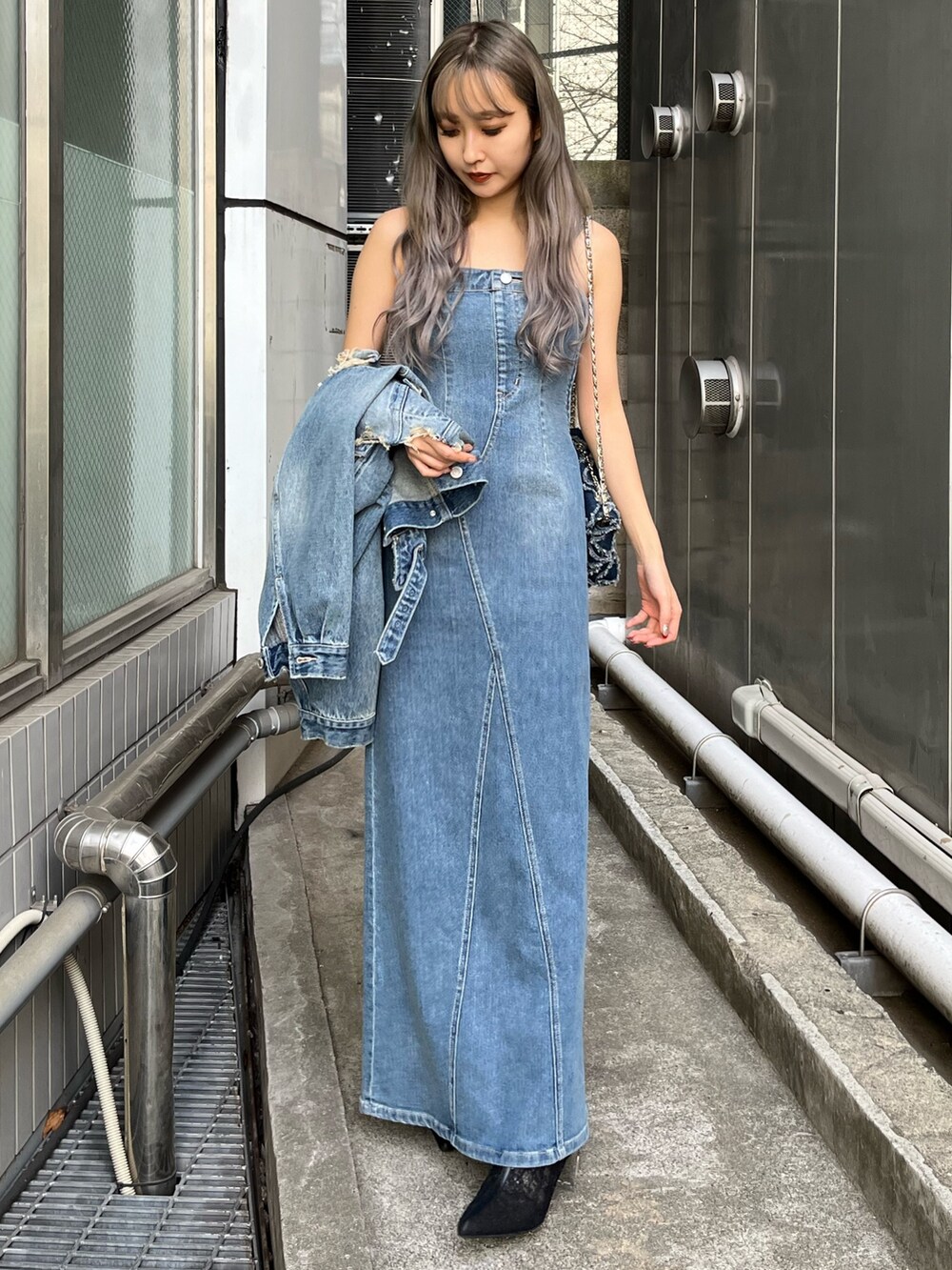 ブルー系のデニムジャケット、ブルー系のワンピース、ブルー系のショルダーバッグを着用したレディースの冬コーディネートの2枚目の写真