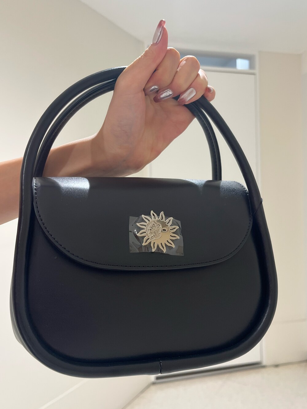 グリーン系のTシャツ/カットソー、ブラック系のブーツ、ブラック系のハンドバッグを着用したレディースの春コーディネートの8枚目の写真