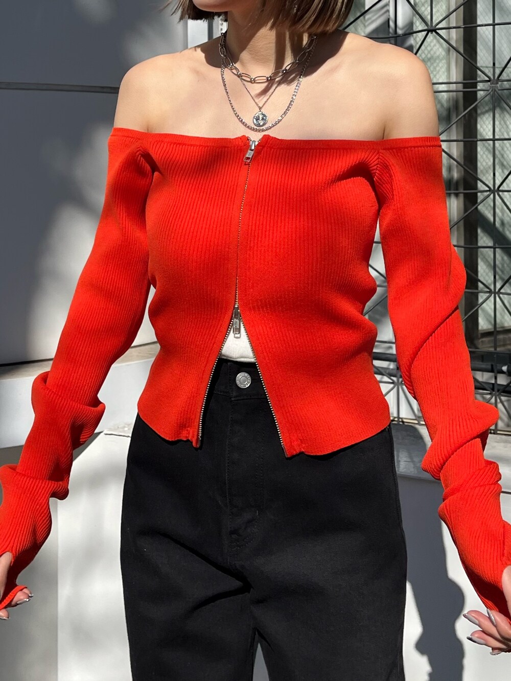 ブラック系のニット/セーター、ブラック系のデニムパンツを着用したレディースの春コーディネートの7枚目の写真