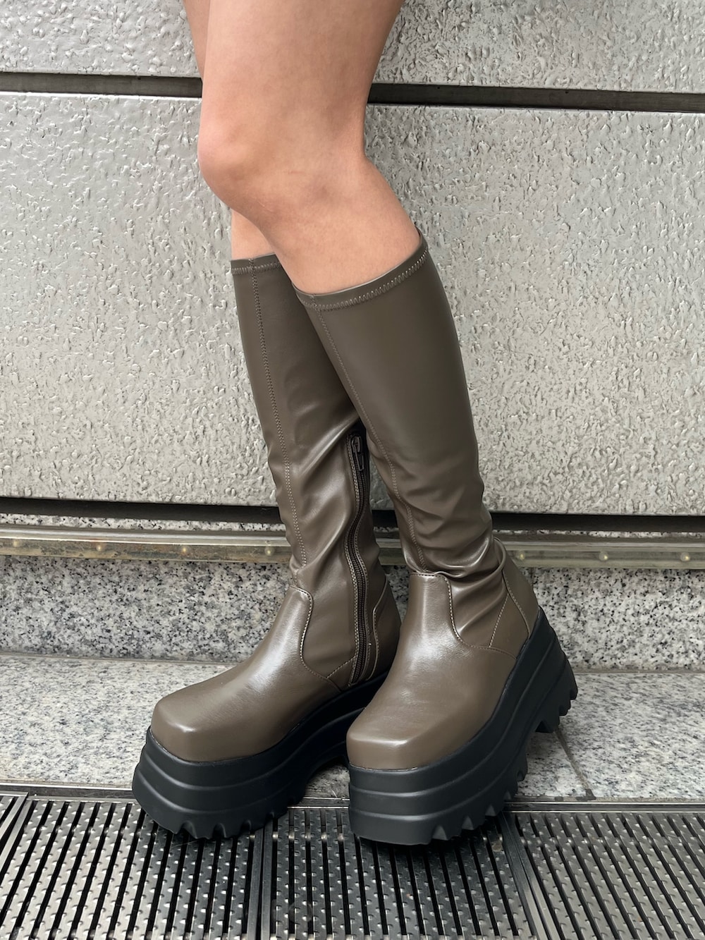 ブラック系のデニムスカート、ブラック系のTシャツ/カットソー、ブラック系のブーツを着用したレディースの冬コーディネートの7枚目の写真