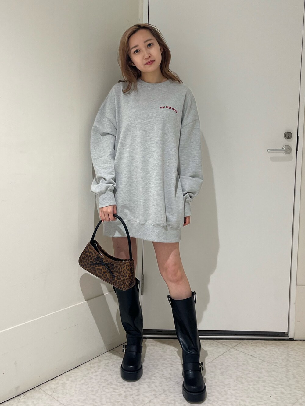 ブラック系のブーツ、ブラウン系のハンドバッグ、グレー系のスウェットを着用したレディースの春コーディネートの4枚目の写真