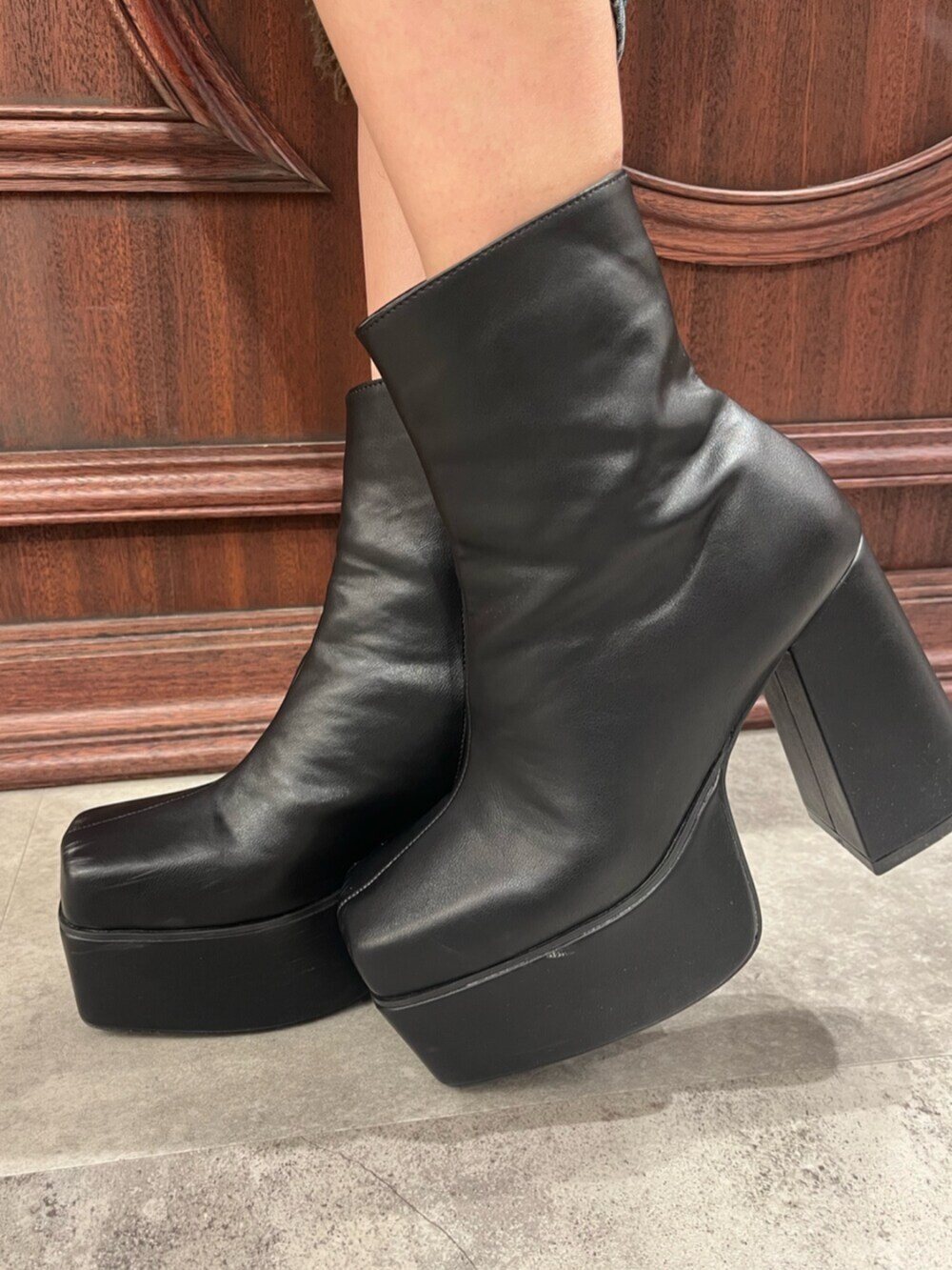 ブラック系のブーツ、ブラウン系のハンドバッグ、ブラック系のデニムパンツを着用したレディースの春コーディネートの7枚目の写真