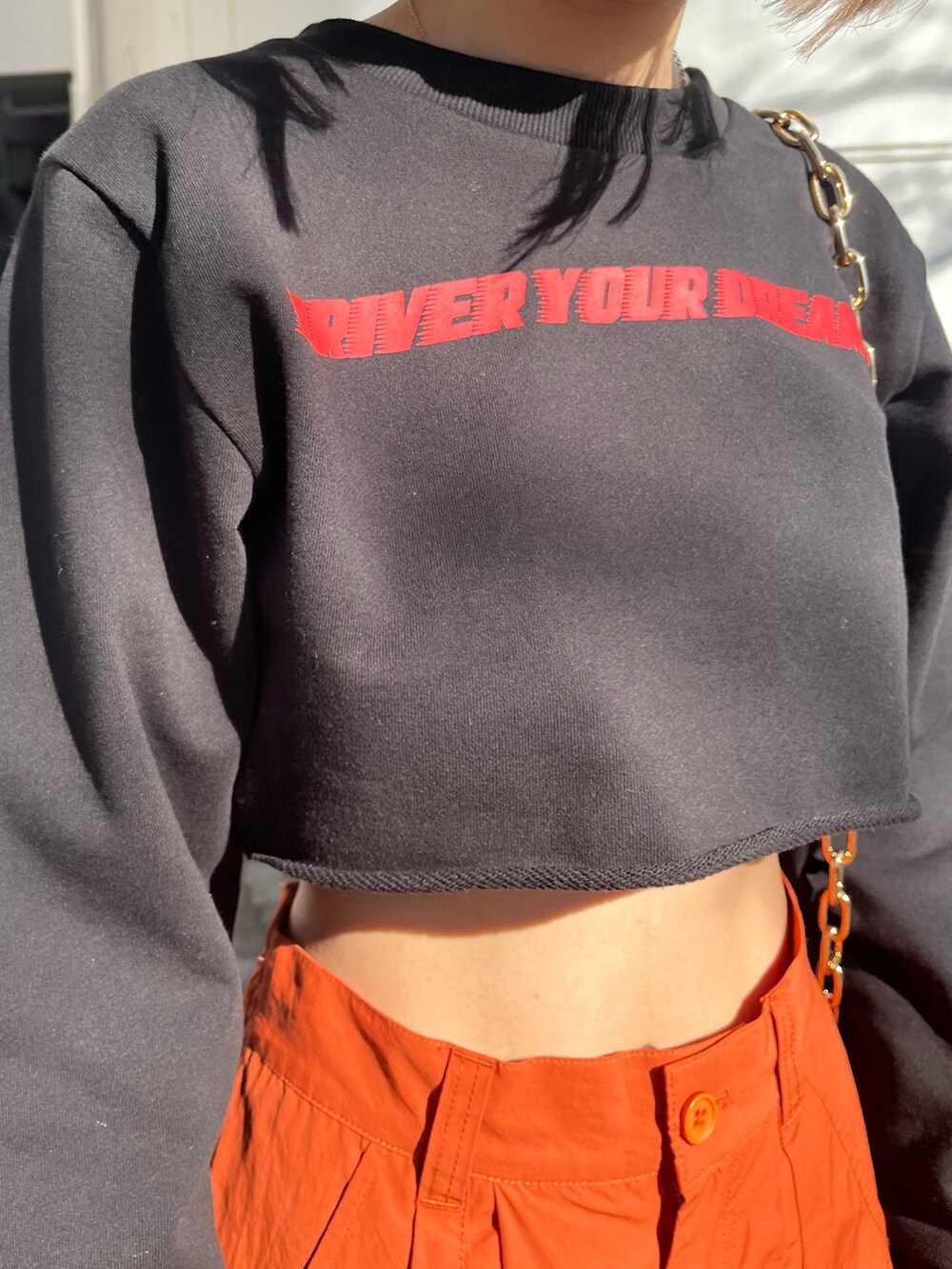 オレンジ系のカーゴパンツ、ホワイト系のブーツ、ブラック系のTシャツ/カットソーを着用したレディースの冬コーディネートの4枚目の写真