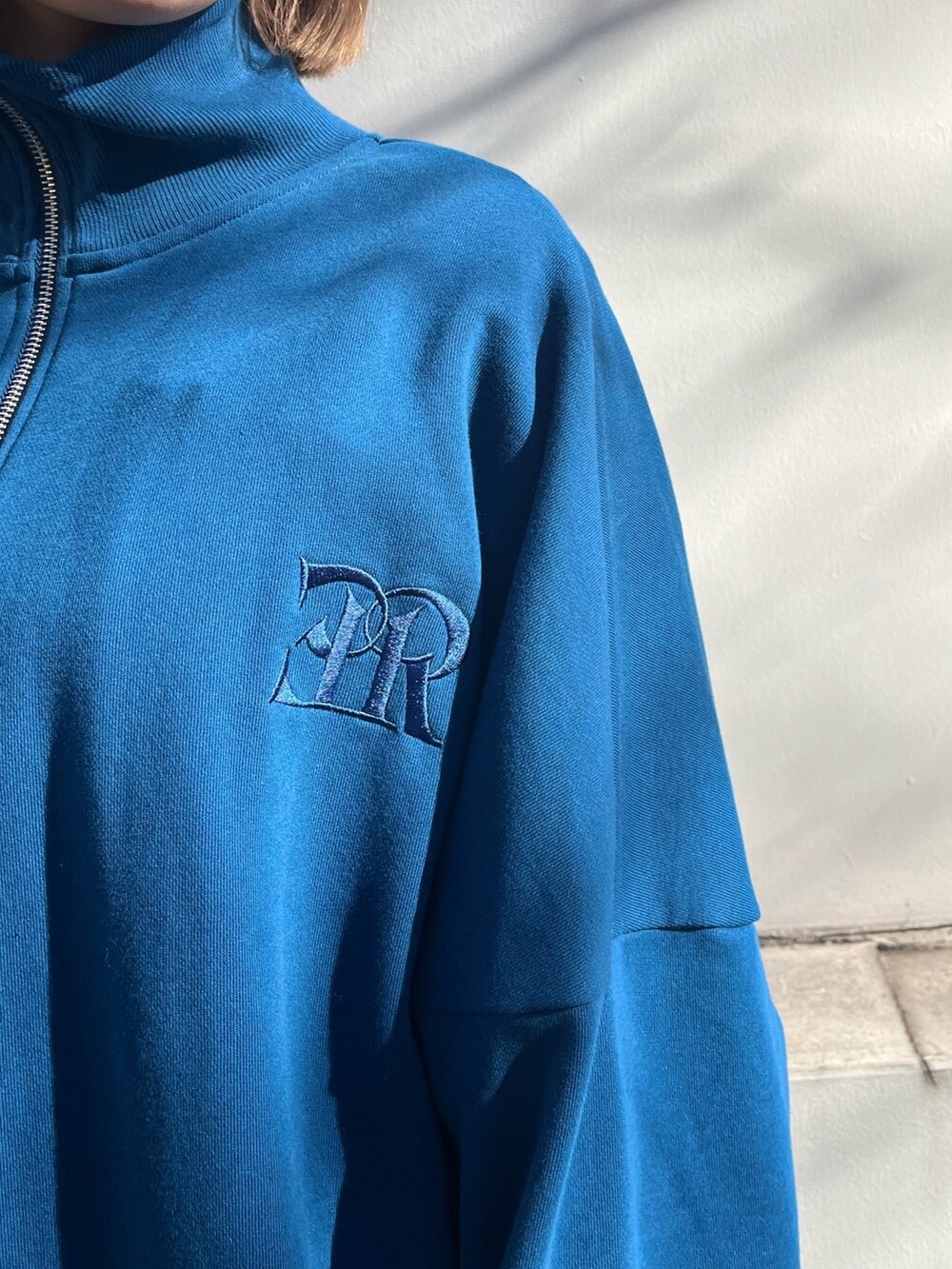 ブルー系のスウェット、ブラック系のブーツを着用したレディースの冬コーディネートの2枚目の写真