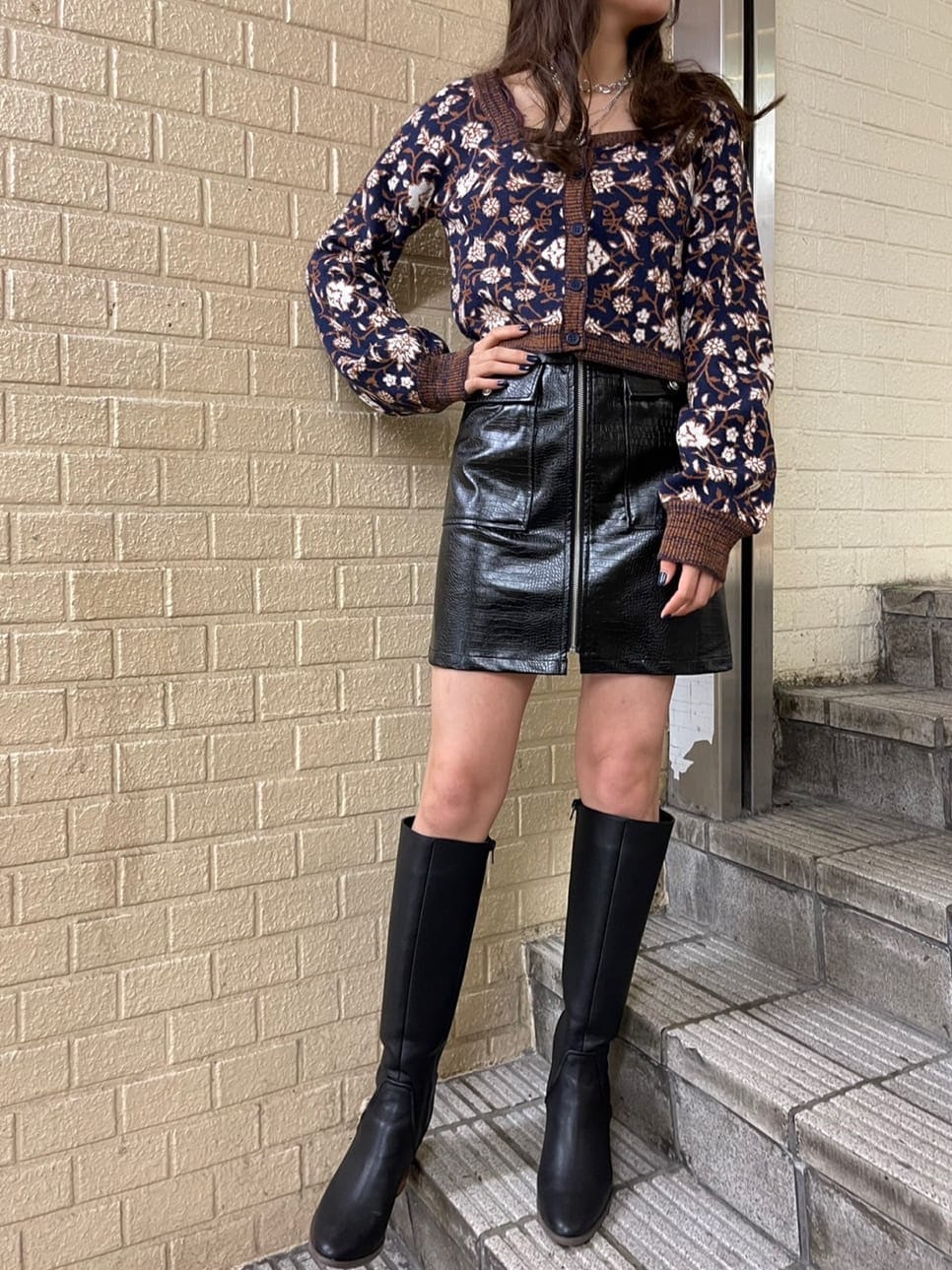 ブルー系のニット/セーター、ブラック系のブルゾン、ブラック系のブーツを着用したレディースの秋コーディネートの2枚目の写真