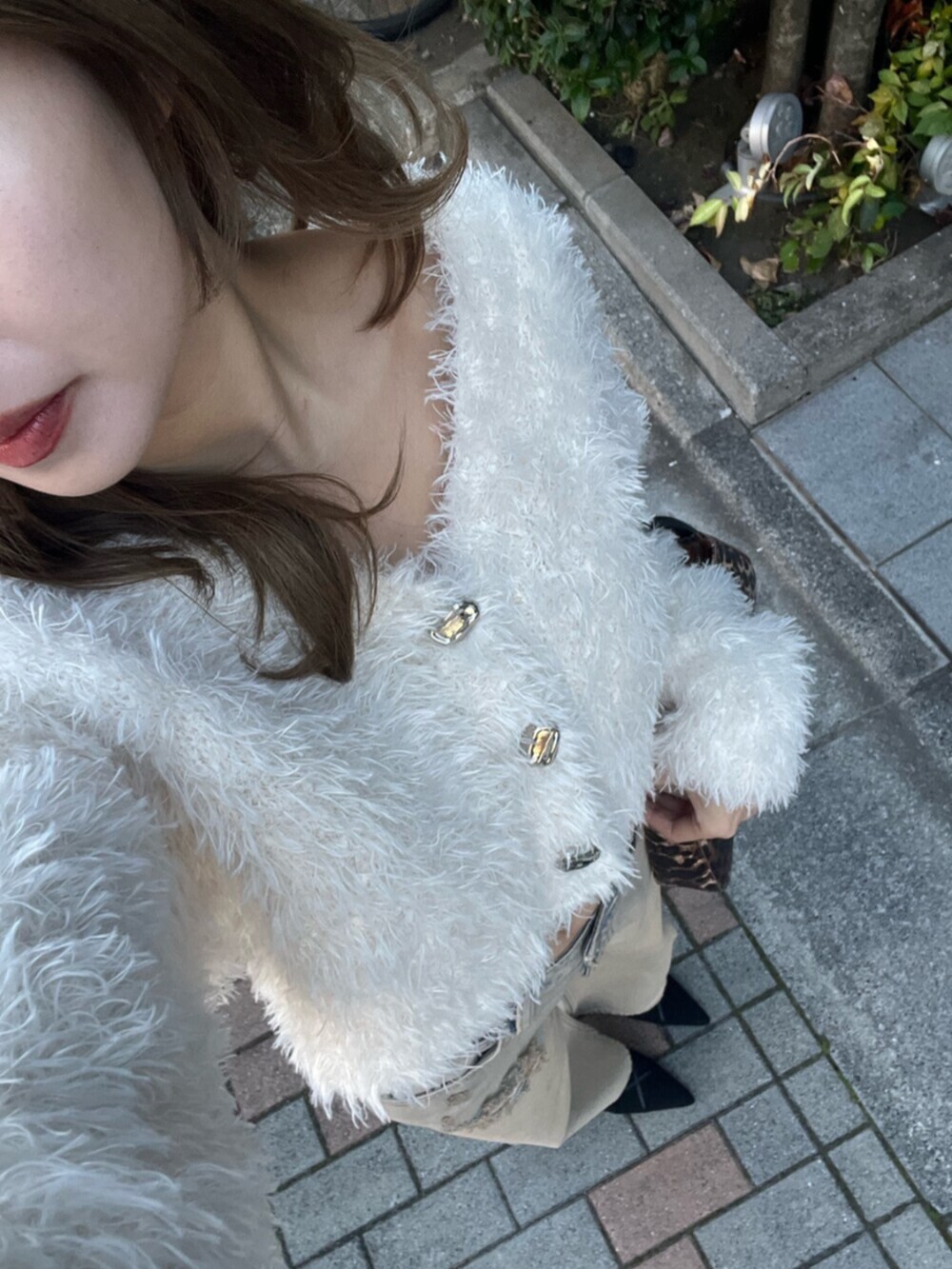 ホワイト系のカーディガン/ボレロ、ベージュ系のデニムパンツ、ブラック系のサンダルを着用したレディースの冬コーディネートの5枚目の写真