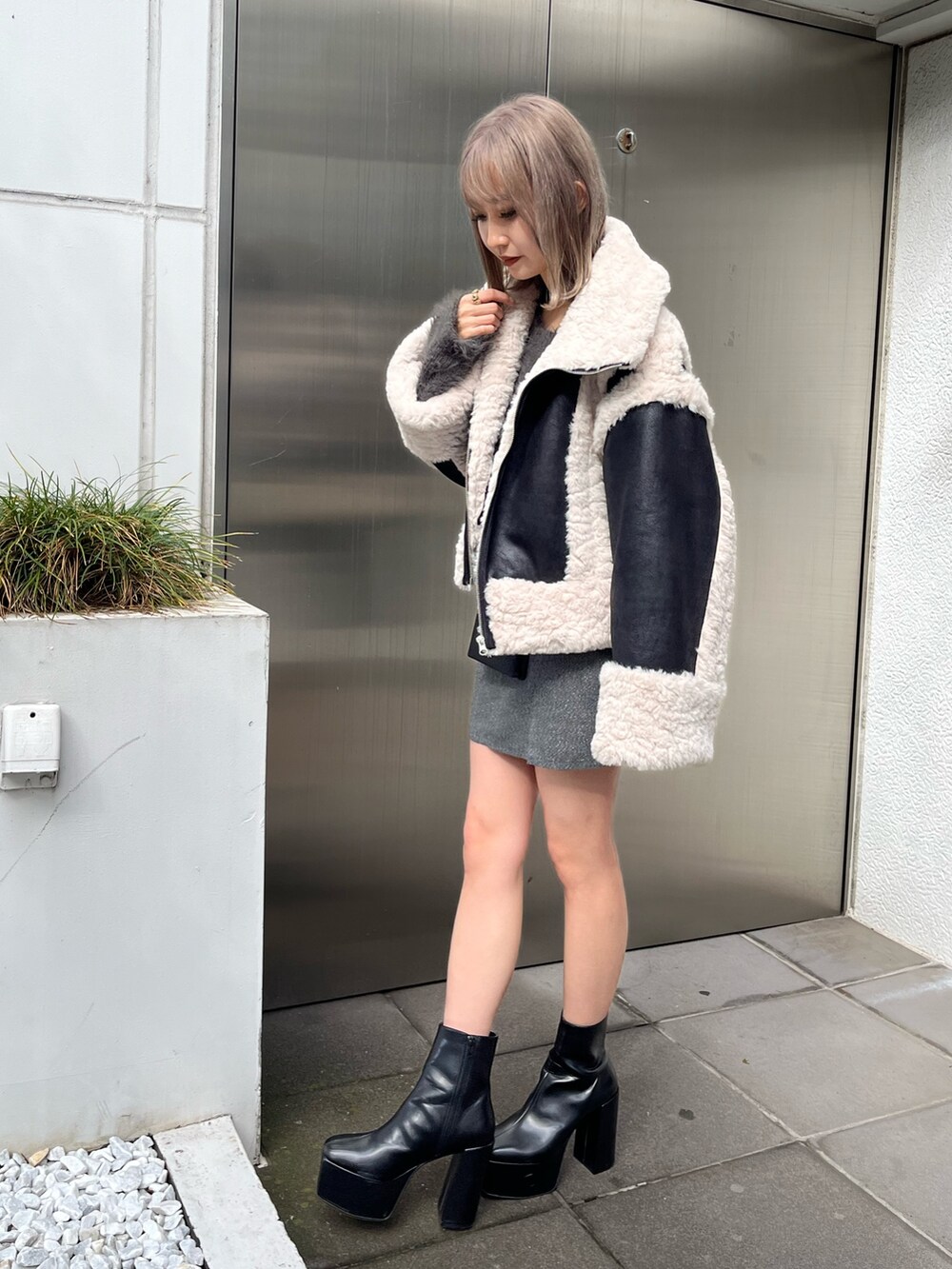ブラック系のブーツ、ブラック系のショルダーバッグ、グリーン系のムートンコートを着用したレディースの冬コーディネートの3枚目の写真